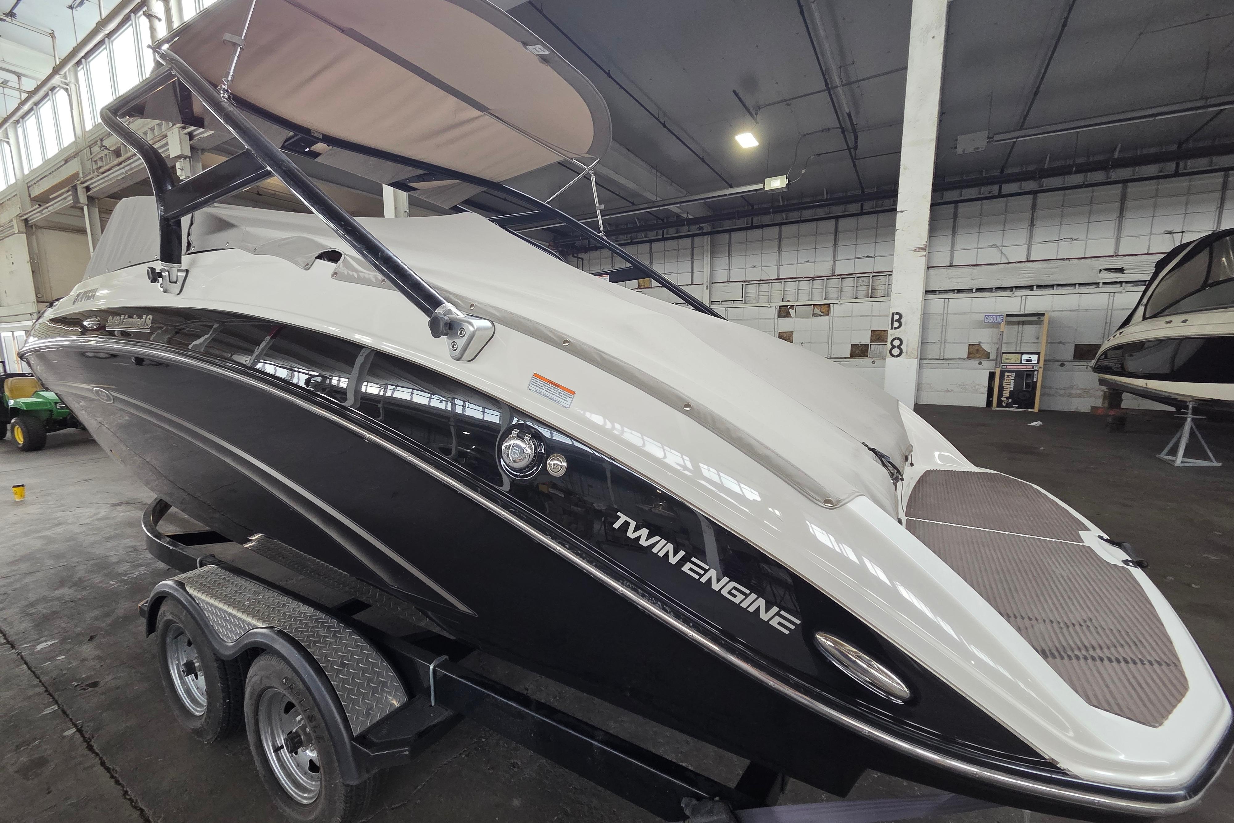 2013 Yamaha 242 Limited S boat with twin engines in a warehouse setting.
