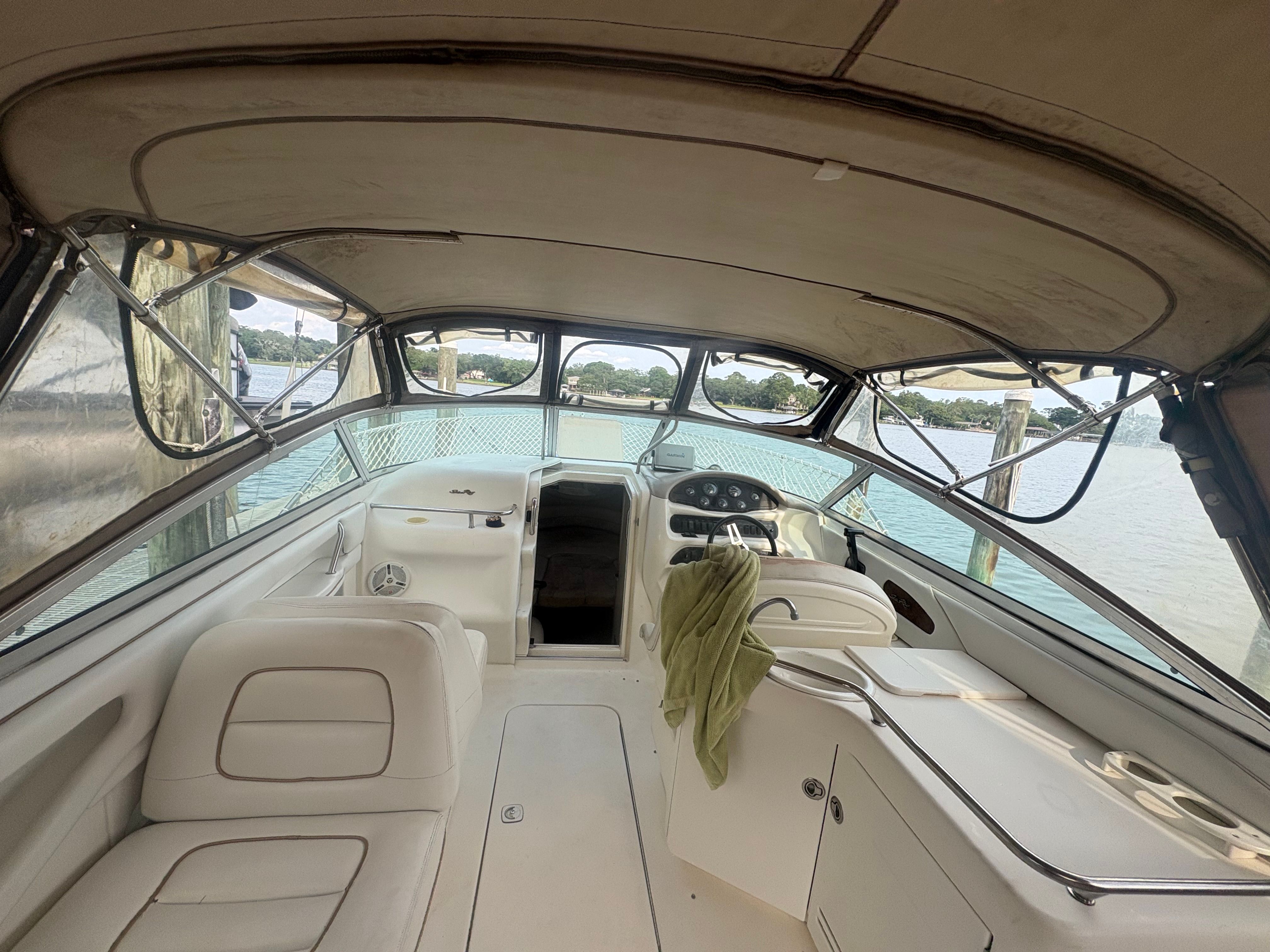 Interior view of a 1996 Sea Ray 280 Cuddy Cabin with beige canopy and white seating.