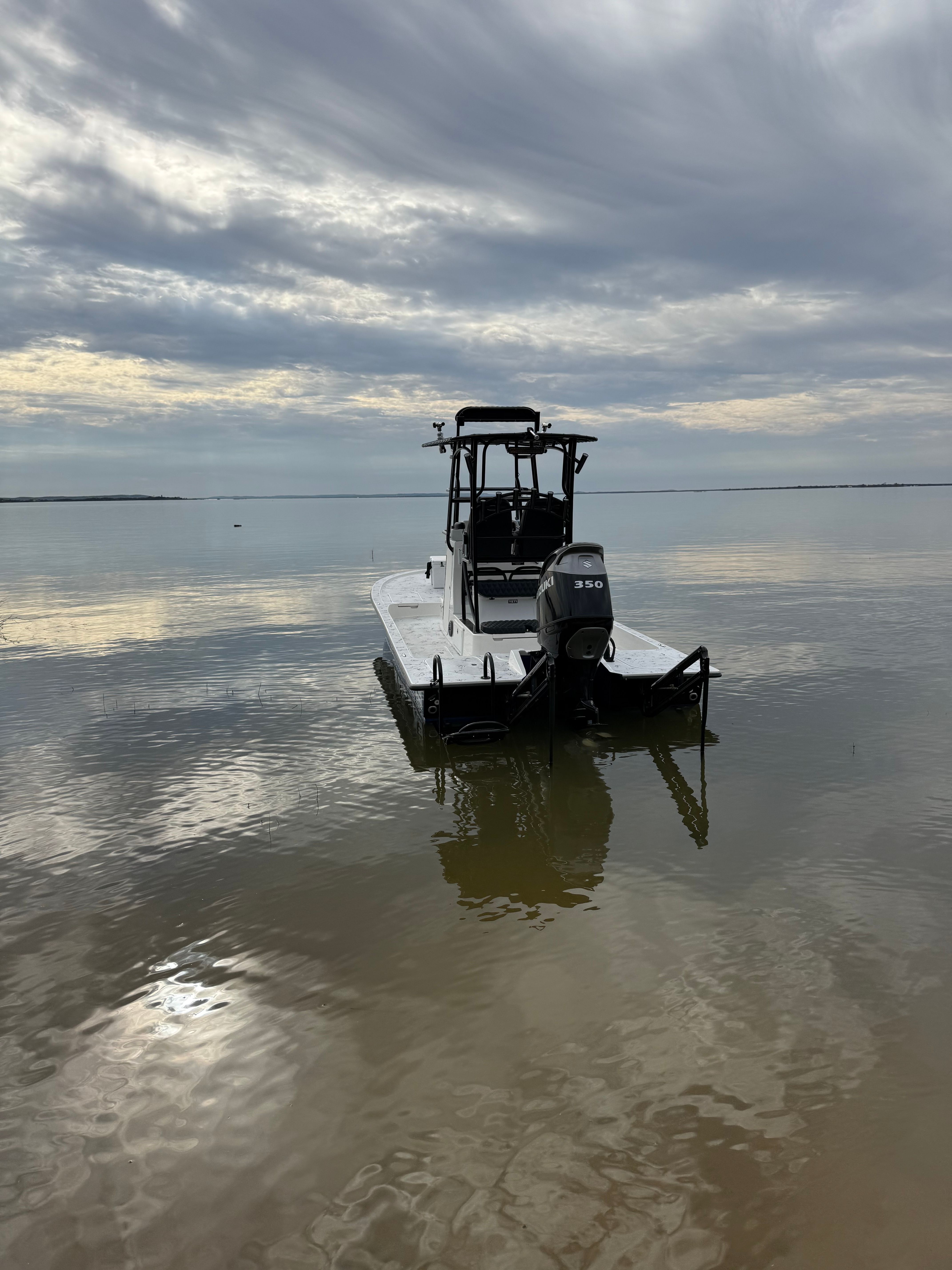 2023 Shallow Sport 25 X3 boat on calm water under cloudy sky.