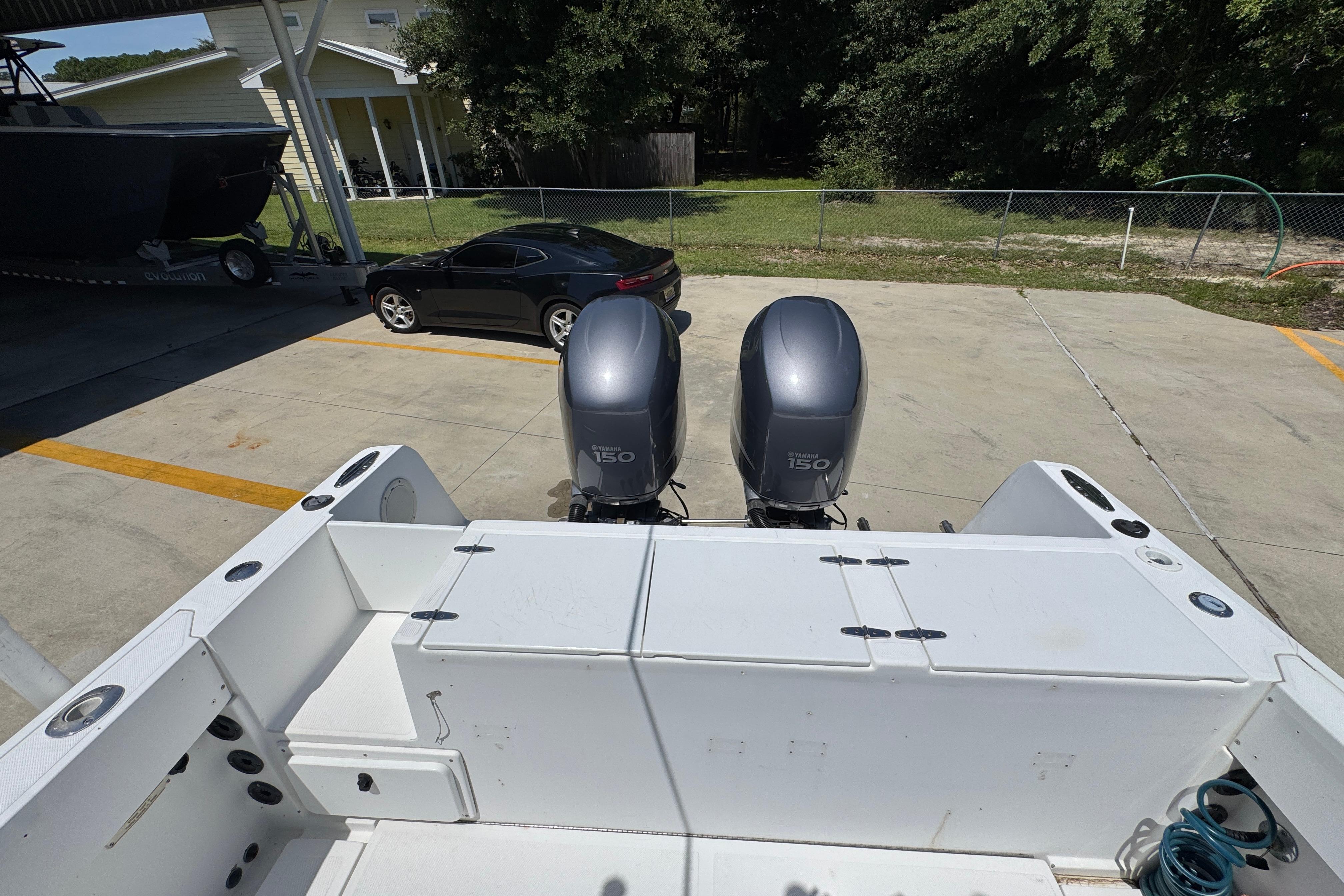 2000 Stamas 250 Tarpon boat with dual Yamaha 150 engines in a driveway setting.