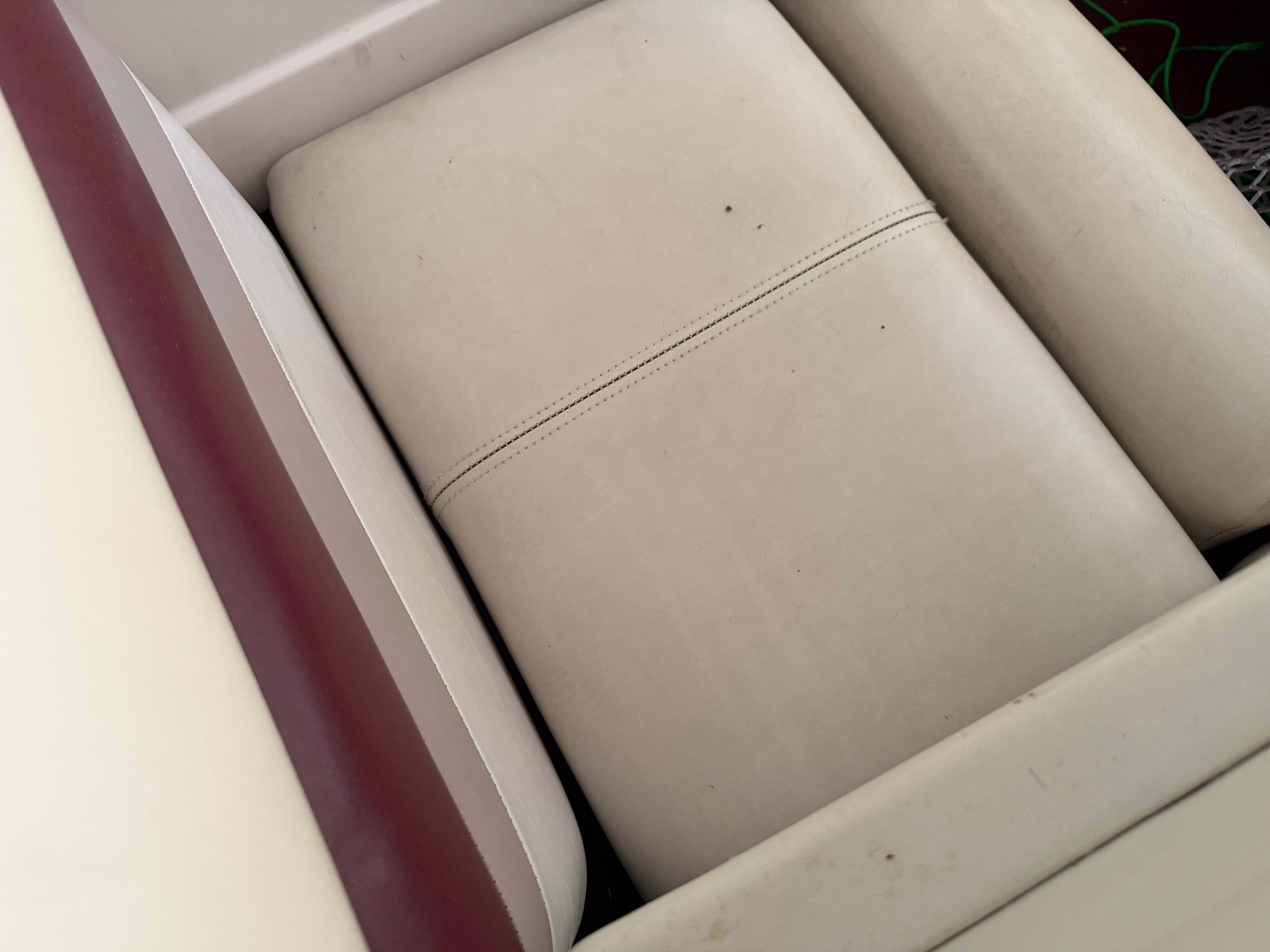 Close-up of a beige boat seat with red accents.
