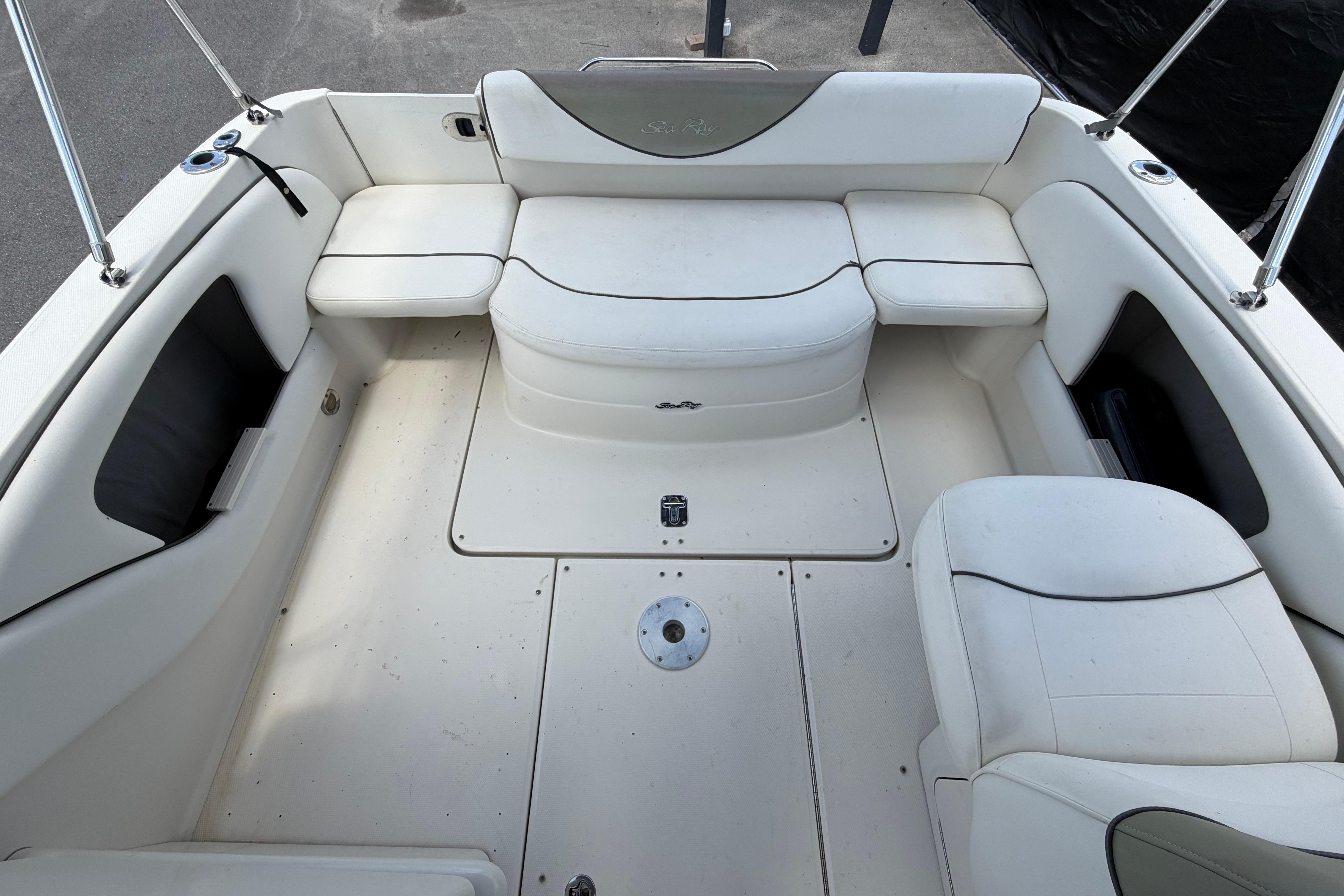 2006 Sea Ray 250 Amberjack boat interior with white seating and storage compartments.