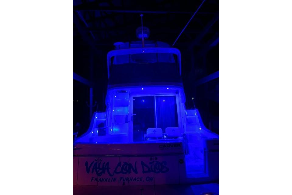 2003 Carver 36 Super Sport yacht illuminated with blue lights at night.