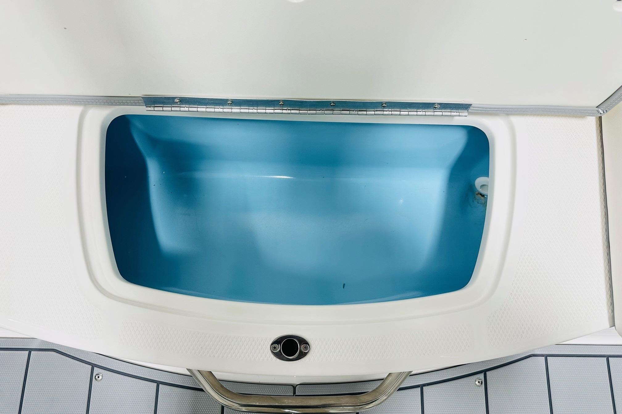 2025 Chaparral 21 SSi OB boat storage compartment with blue interior.