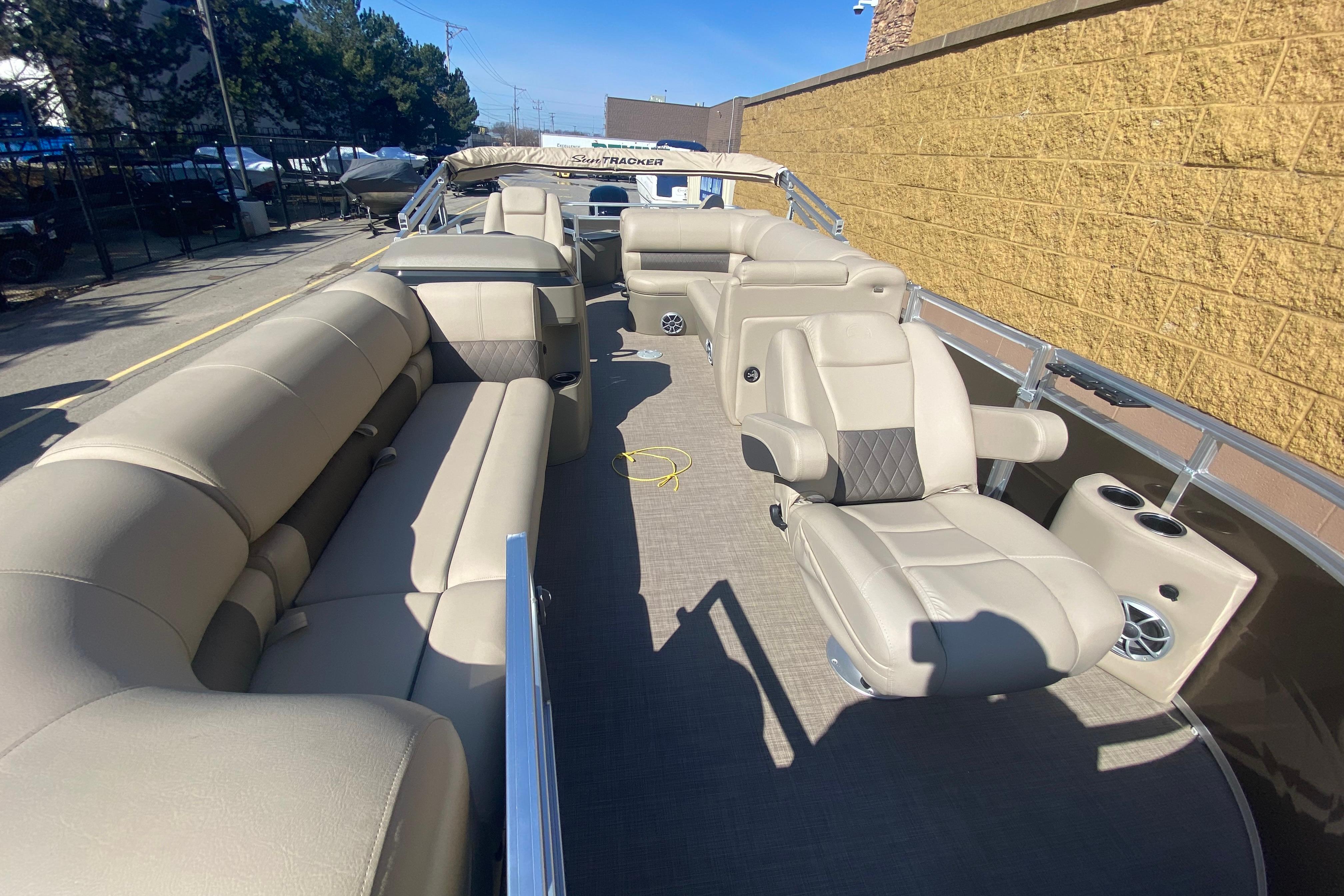2025 Sun Tracker SportFish 20 DLX pontoon boat with beige seating and spacious deck.