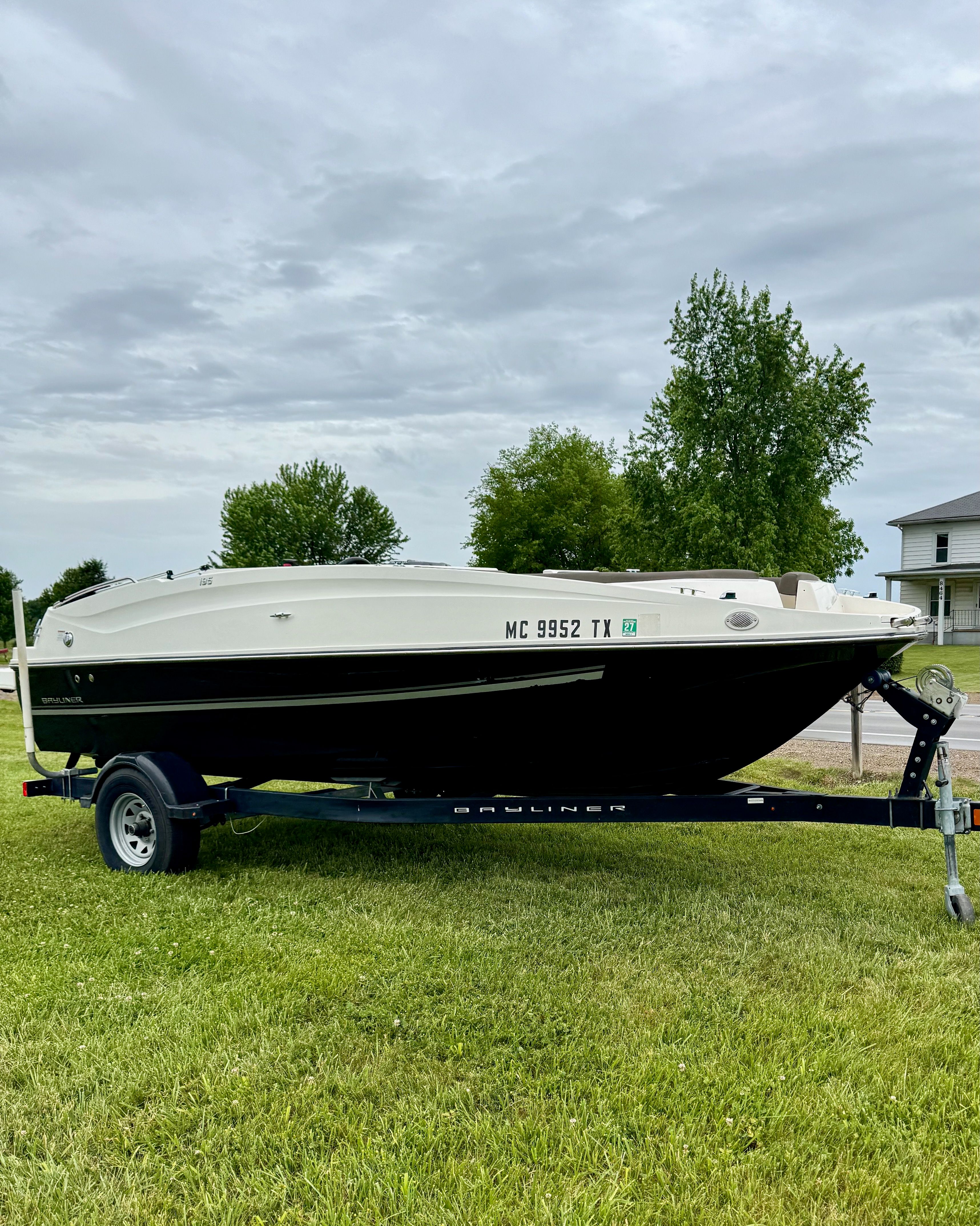 2017 Bayliner Element E18 on a trailer on a grassy field.