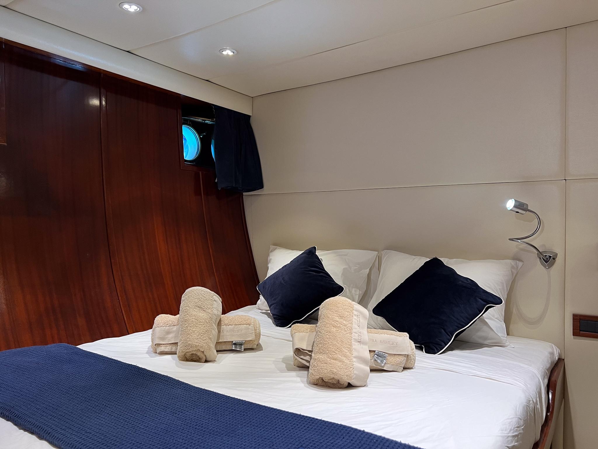 Luxurious cabin interior of 1969 Psarros Shipyard yacht with elegant bedding and wooden paneling.