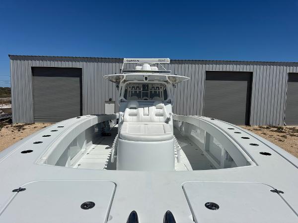 2022 Freeman 42LR boat with spacious deck, docked near industrial buildings.