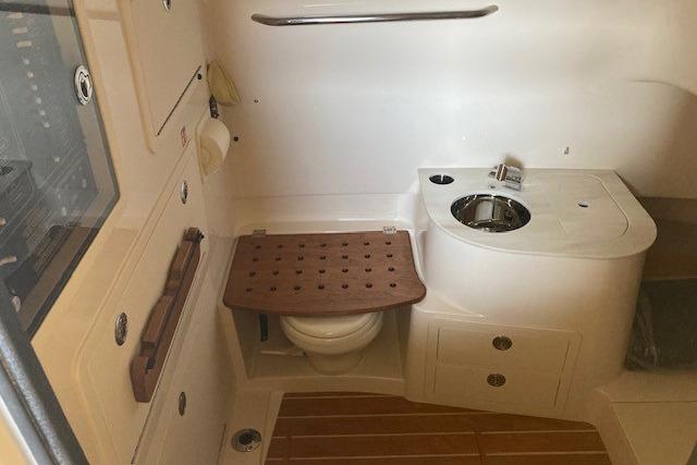 2026 Grady-White Canyon 336 boat interior with compact bathroom and wooden accents.
