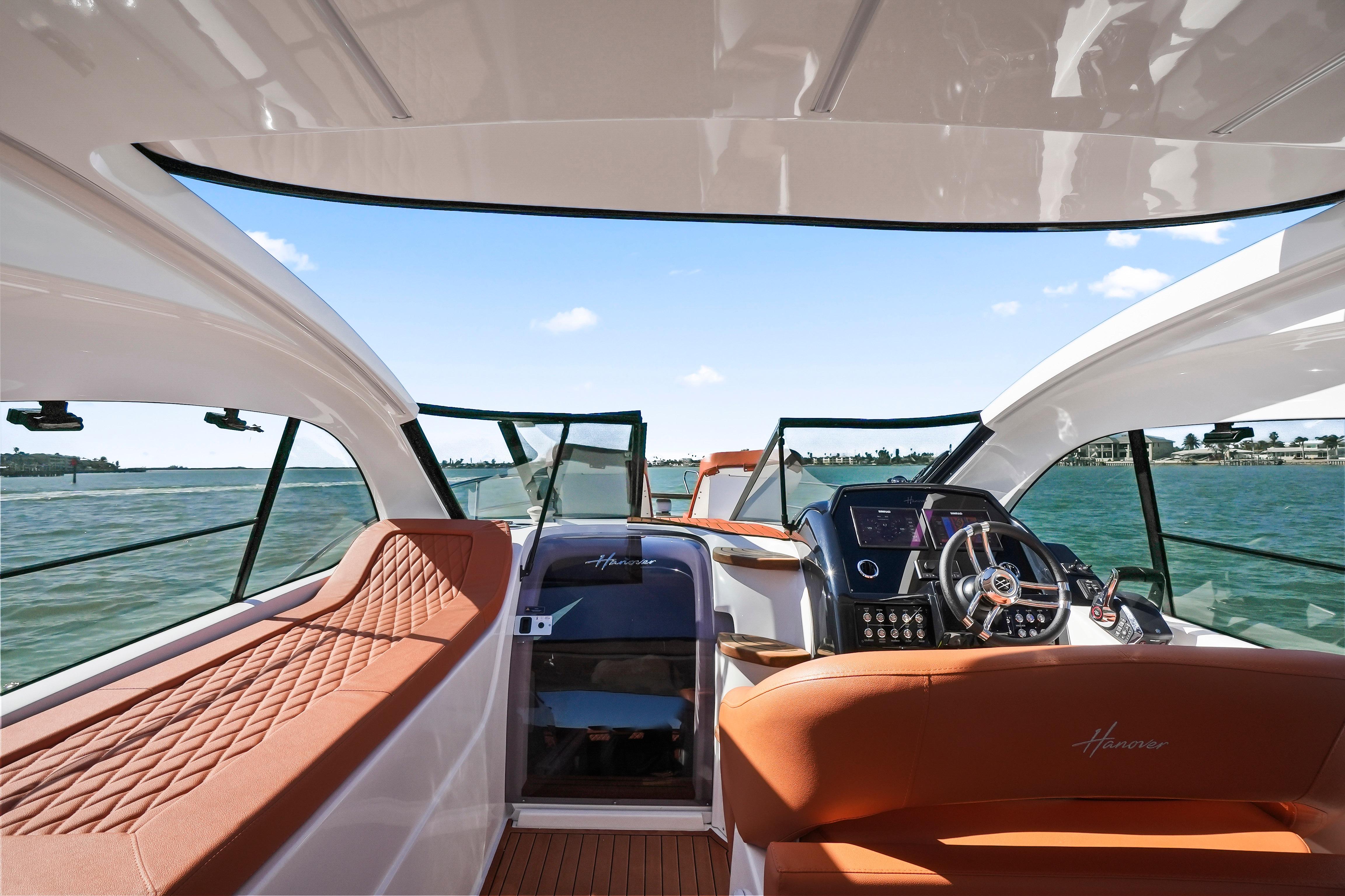 Interior view of 2026 Hanover 355 boat with luxurious seating and modern dashboard.