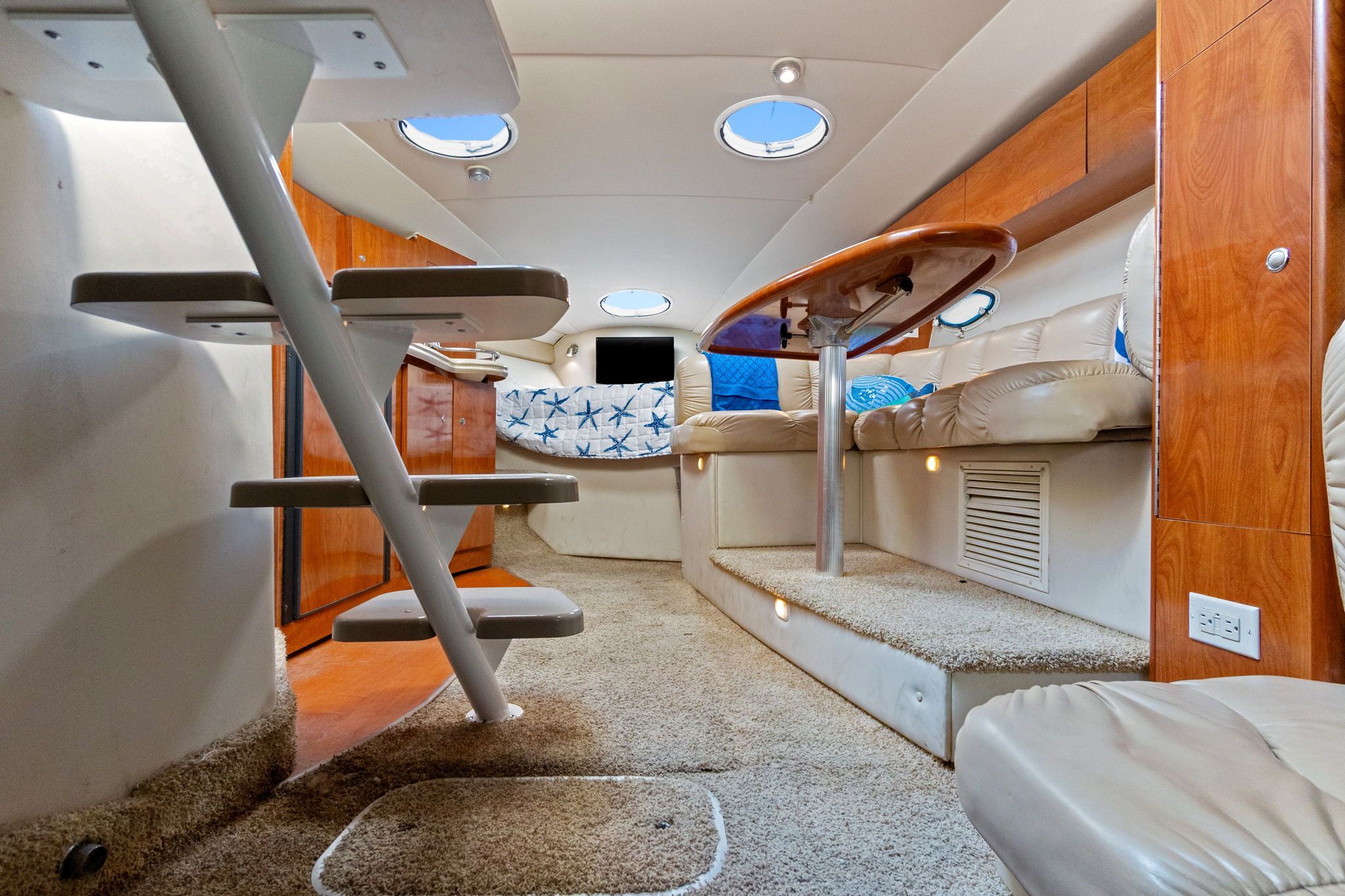 Interior of the 2007 Larson Cabrio 330 with cozy seating and carpeted flooring.