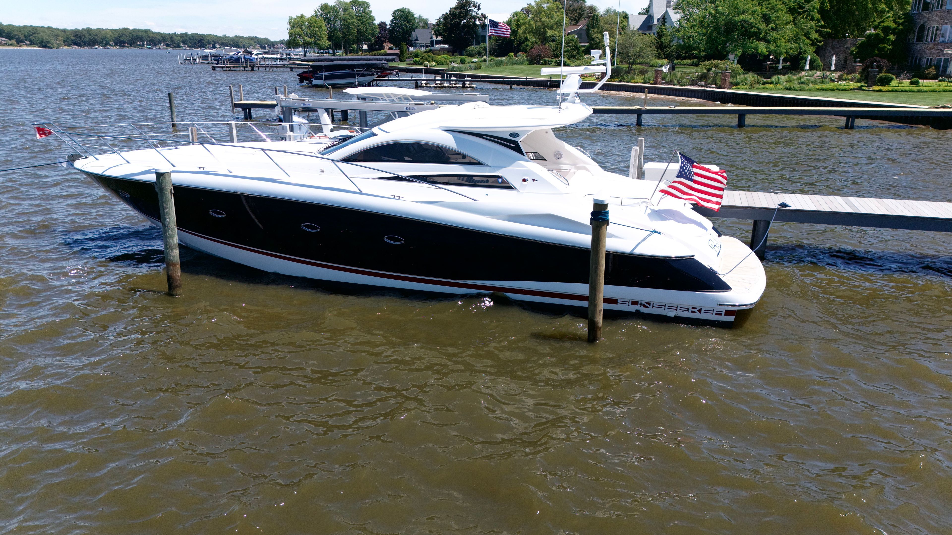 A 2008 Sunseeker Portofino 53 docked in calm waters, with a sleek design and flags displayed.