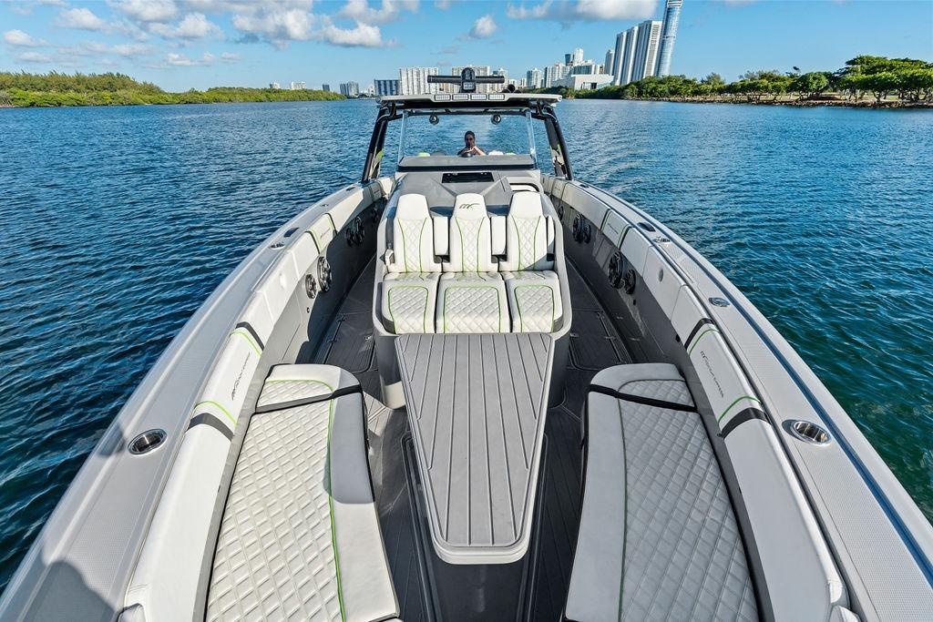 2022 Midnight Express 43' Solstice luxury boat on calm water with city skyline.