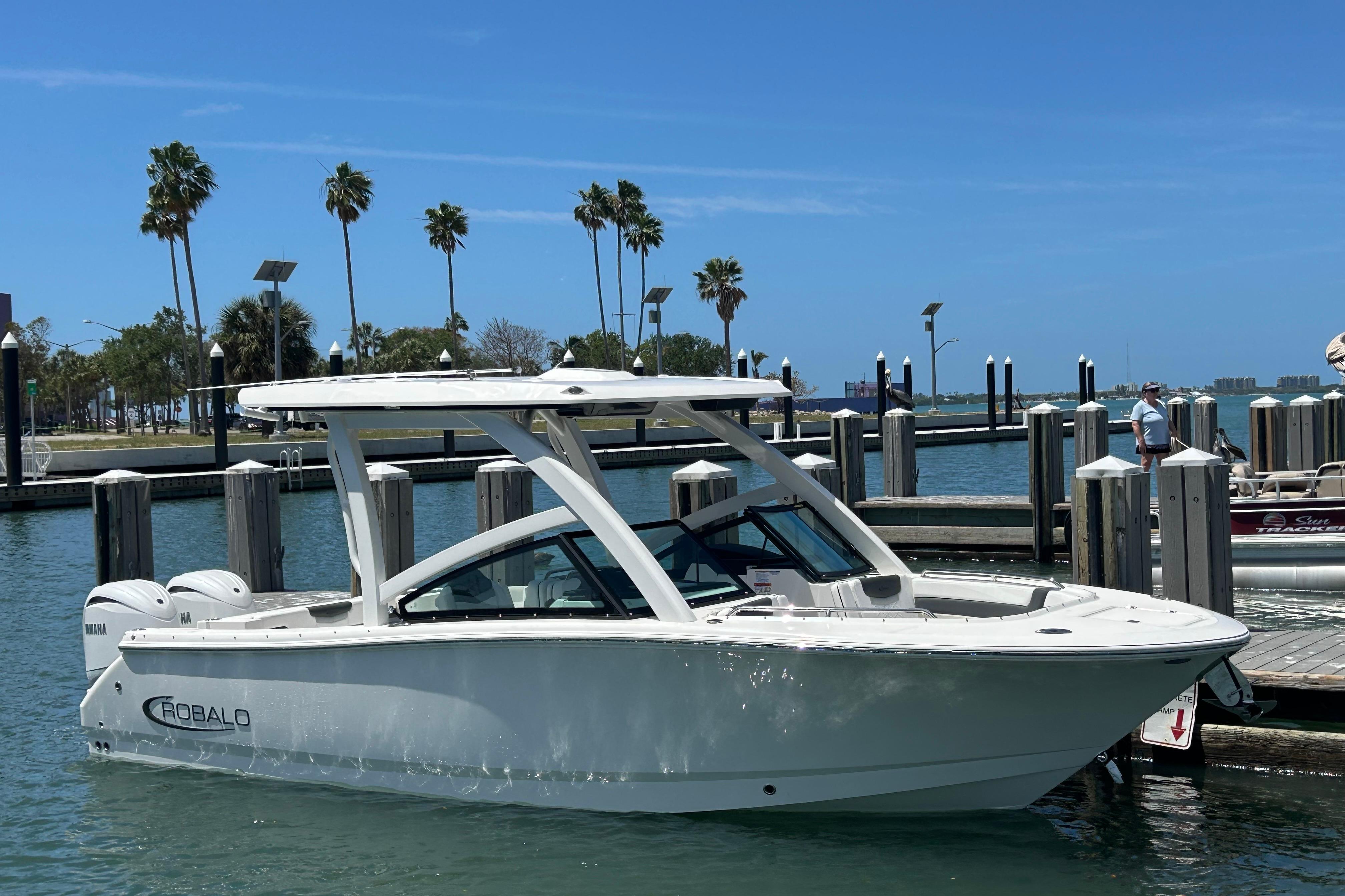 2026 Robalo R257 Dual Console boat docked at marina under clear blue sky.