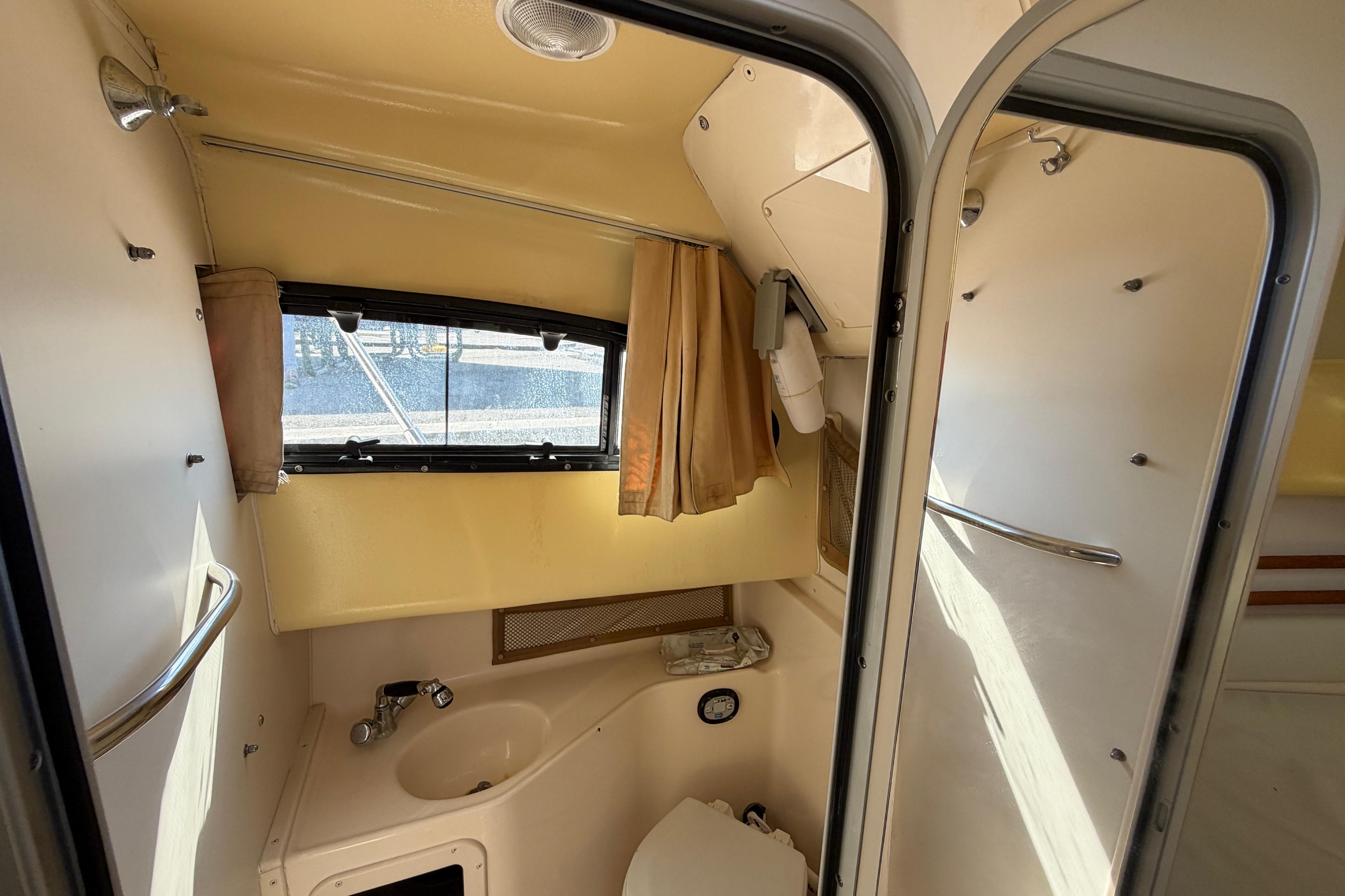 2006 Grady-White Sailfish 282 boat interior with compact bathroom, sink, and window.