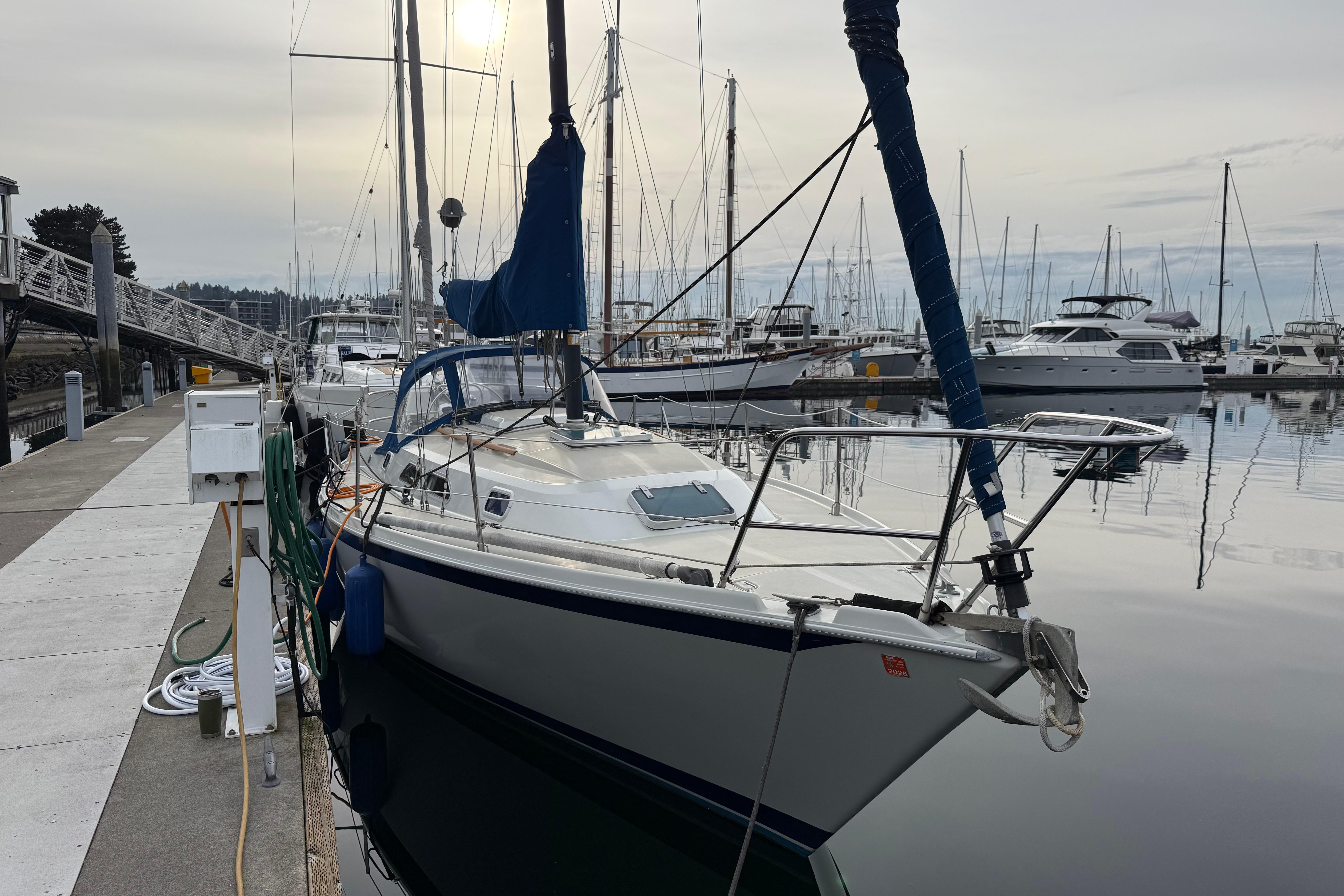 Sailboat Ericson 32-200, 1988 model, docked at a marina with calm waters.