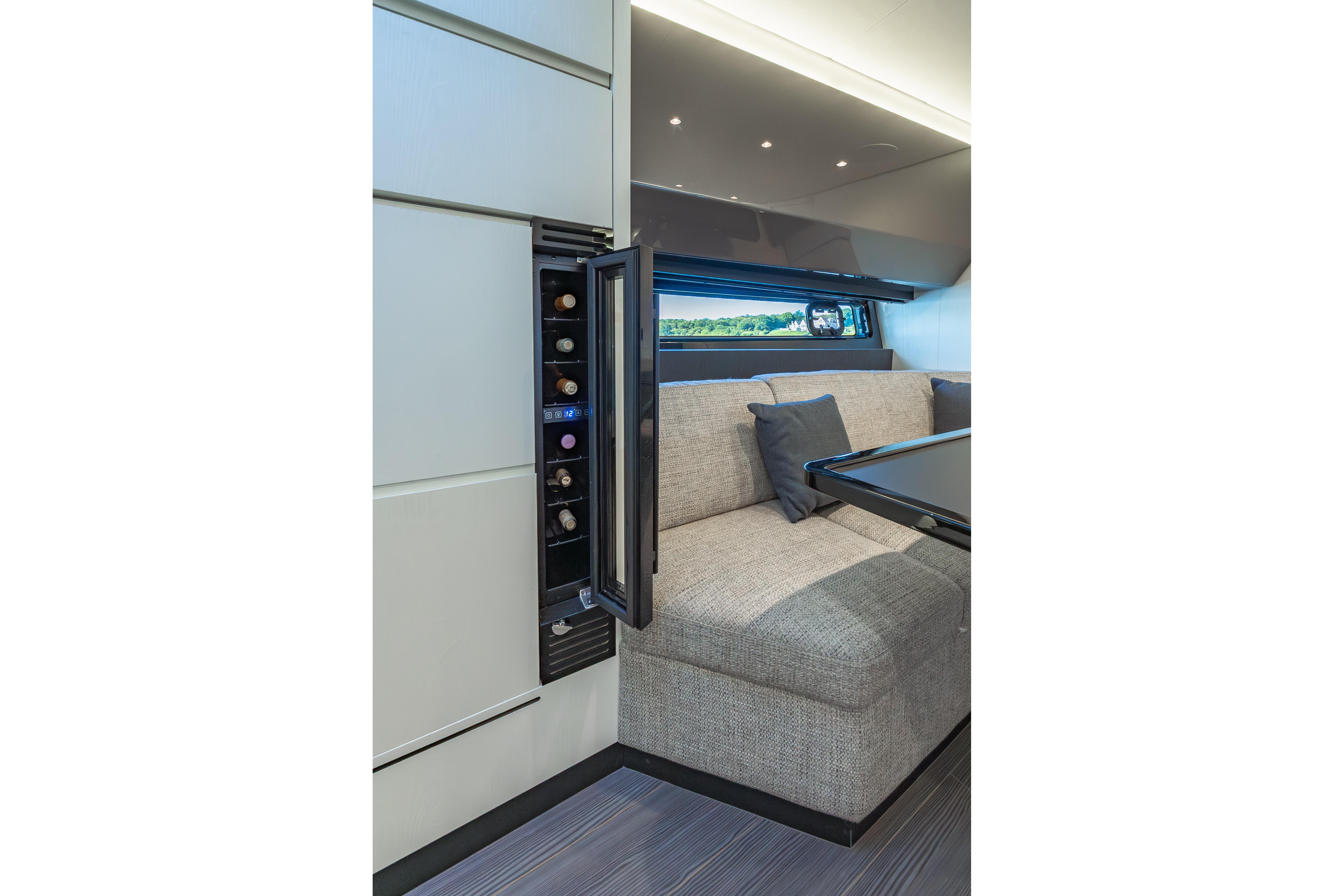 Luxurious interior of 2023 Azimut Verve 47 yacht with wine storage and cozy seating area.