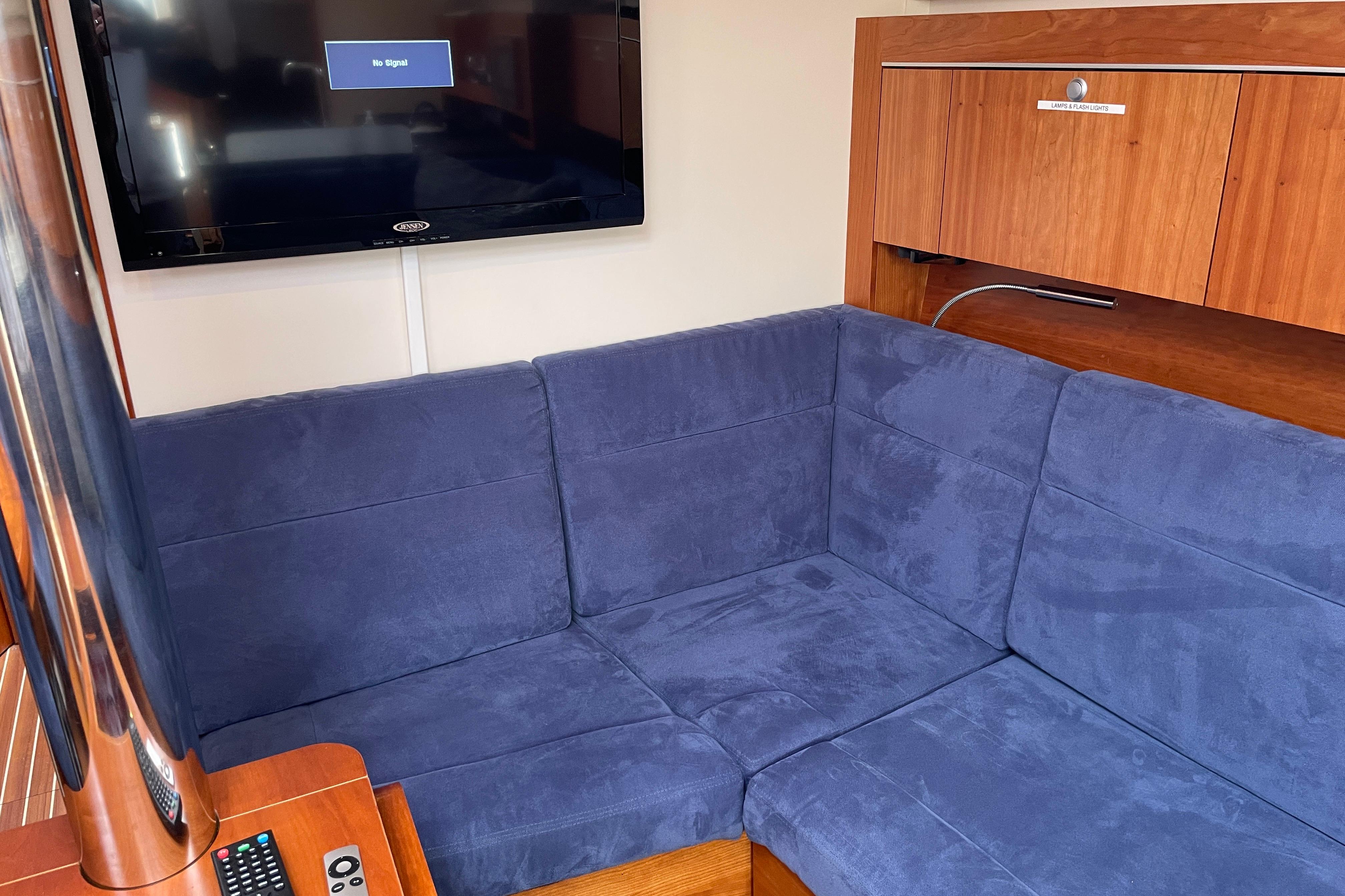 Interior of a 2014 Hanse 415 yacht with blue seating and a wall-mounted TV.