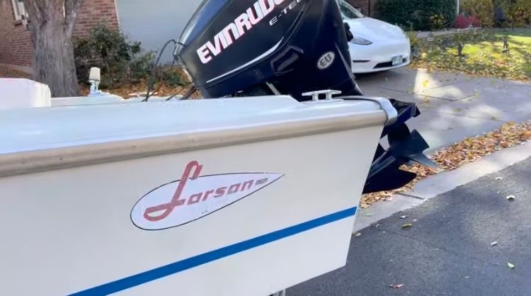1962 Larsen 13 boat with Evinrude motor on street.