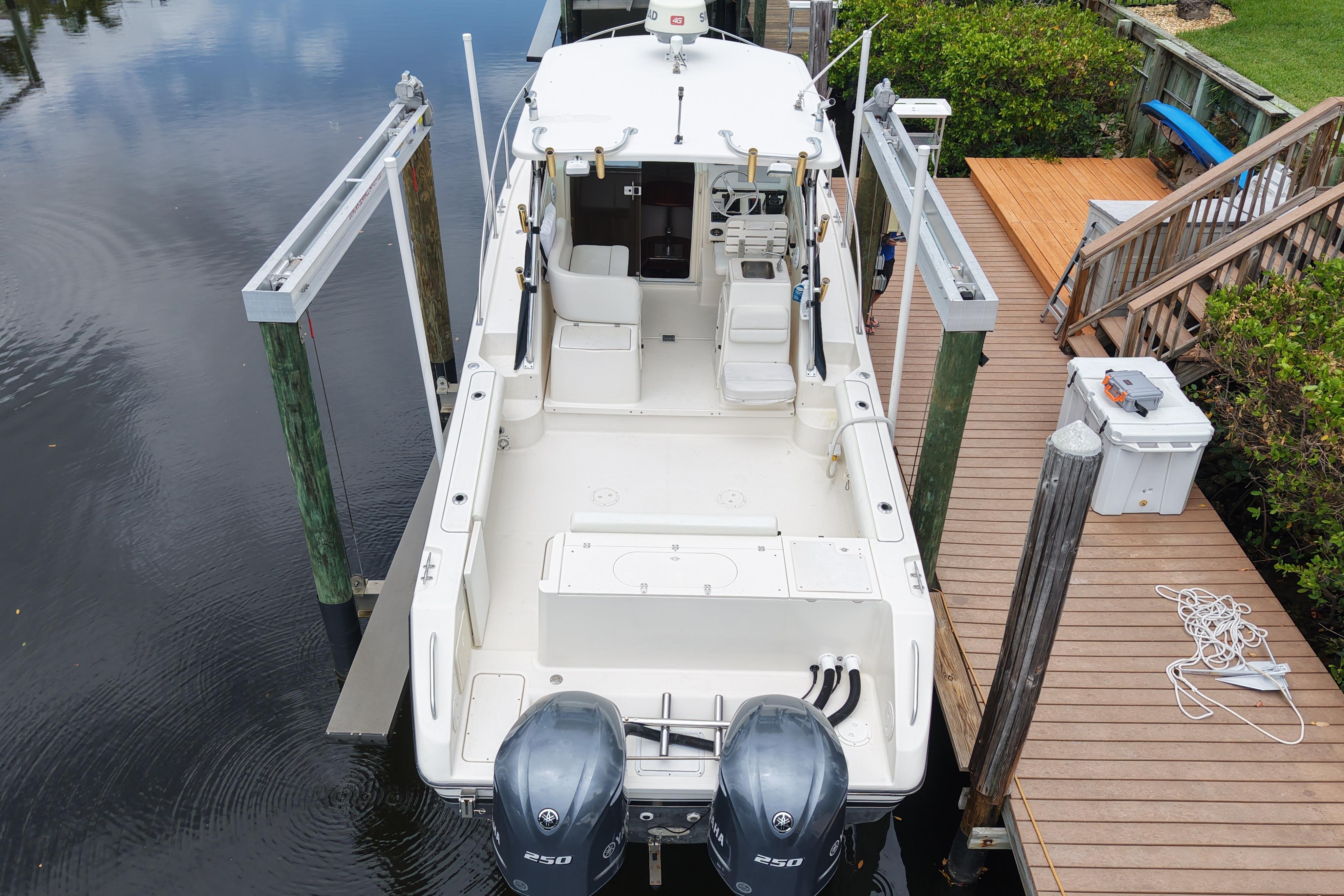 2005 Pursuit 3070 Offshore boat docked with dual engines and spacious deck.