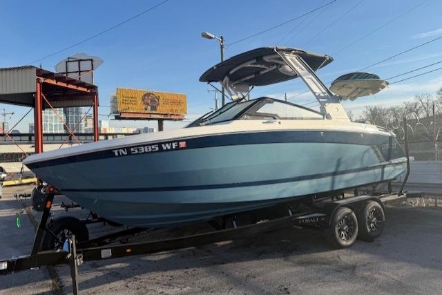 2023 Cobalt R6 Surf boat on trailer, blue hull, parked outdoors.