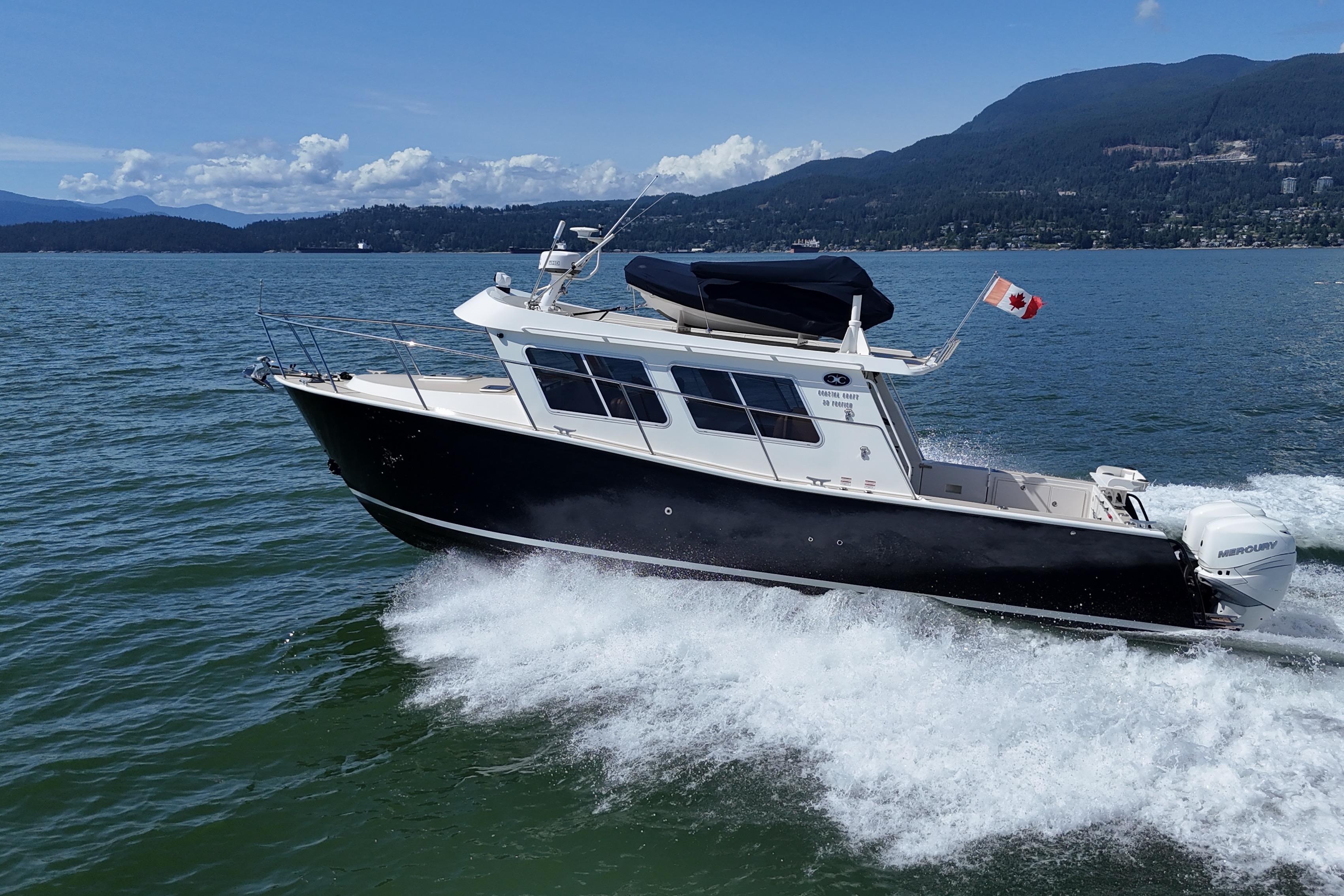 2020 Coastal Craft 33 ProFish boat cruising on scenic waters with Canadian flag.