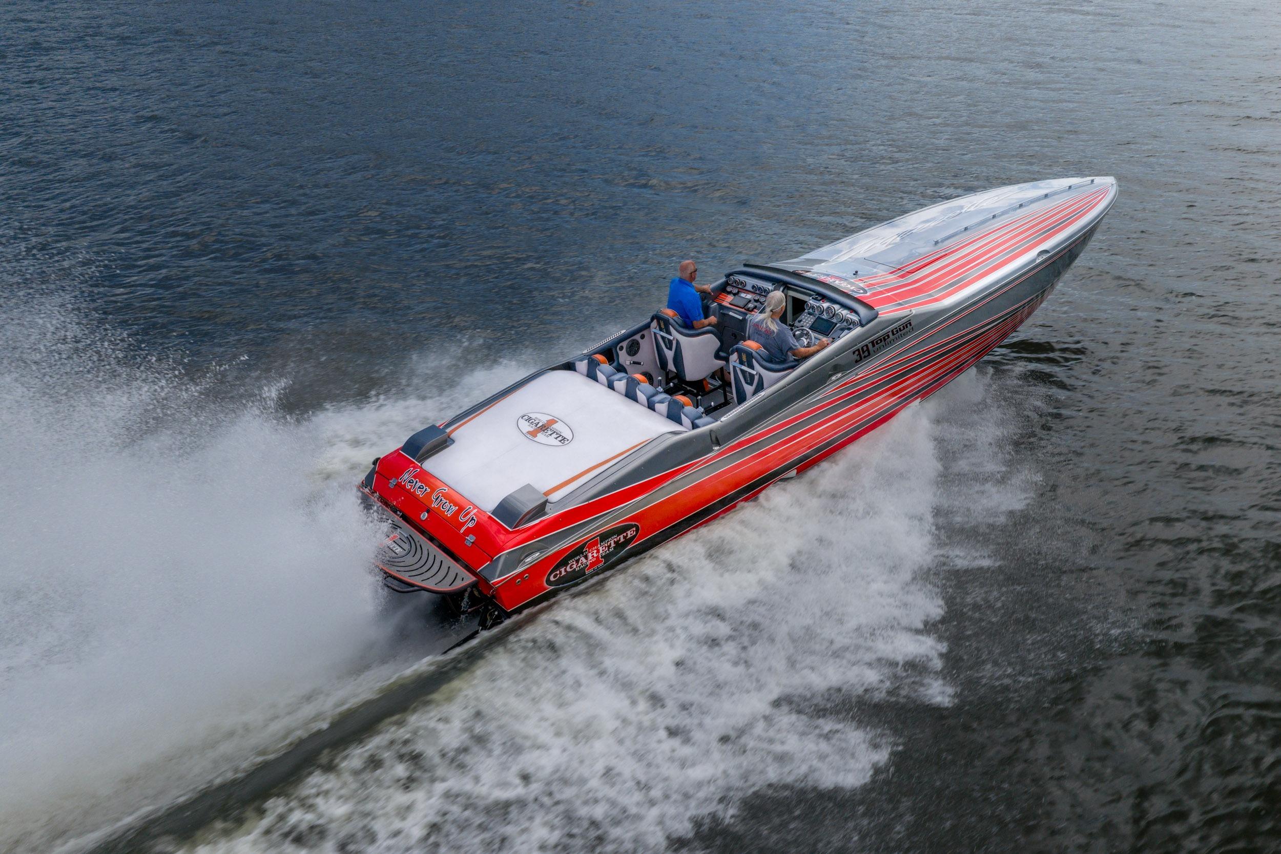 2006 Cigarette 39' Top Gun speedboat cruising on water, featuring vibrant red and silver design.