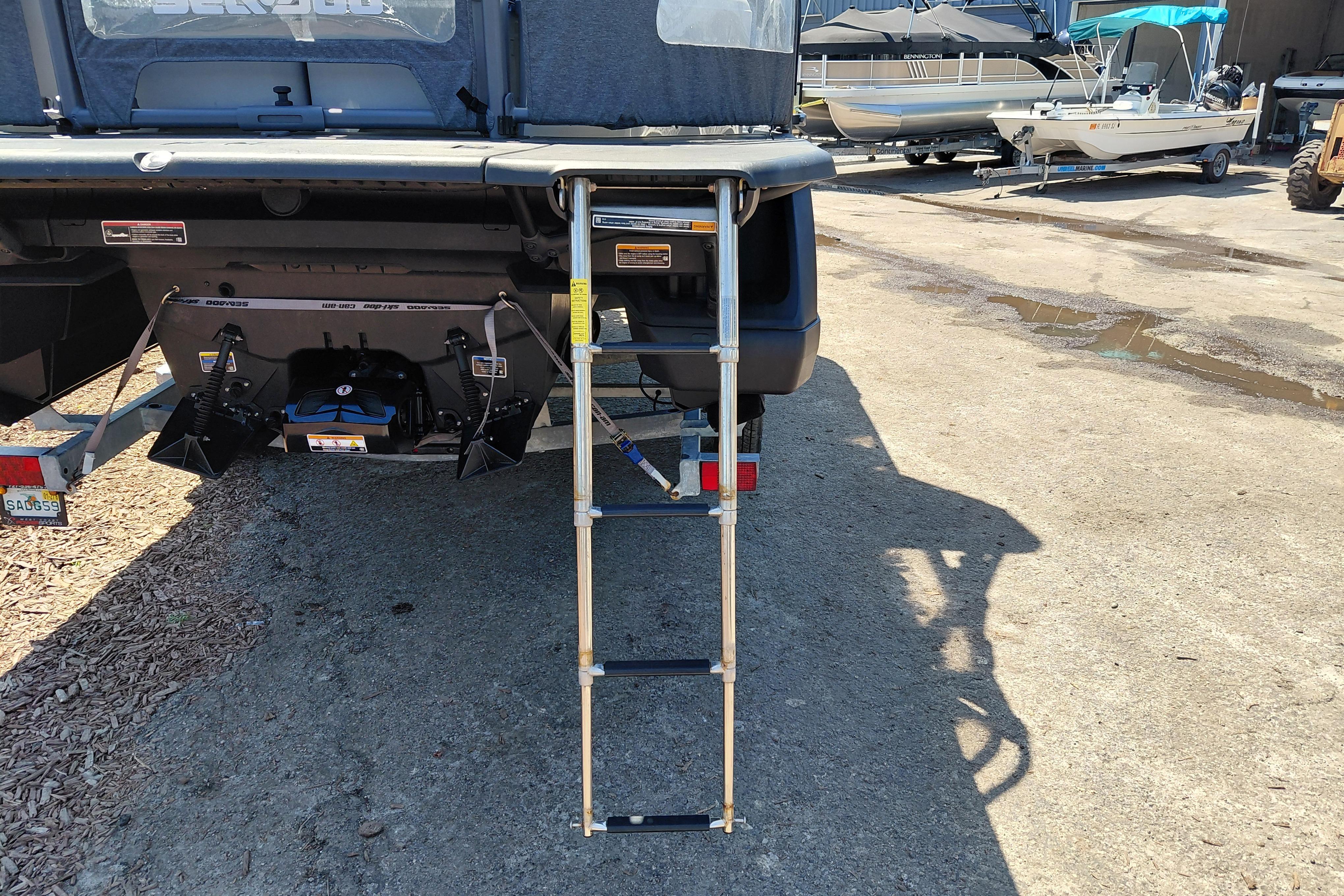 2024 Sea-Doo Switch Cruise 18 with rear ladder and trailer, parked on concrete.