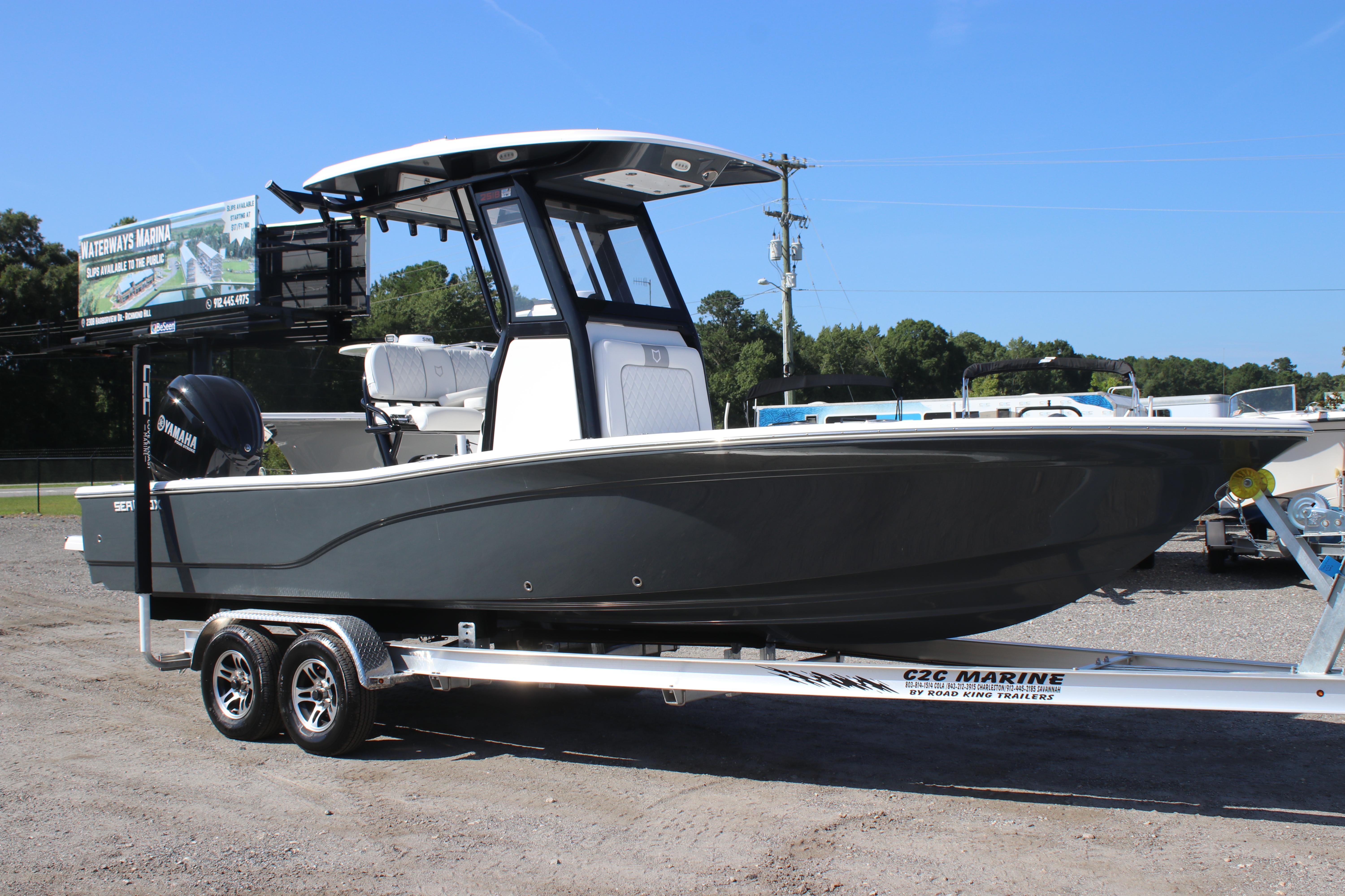2025 Sea Fox 251 Bay Fox boat on trailer, parked outdoors under clear blue sky.
