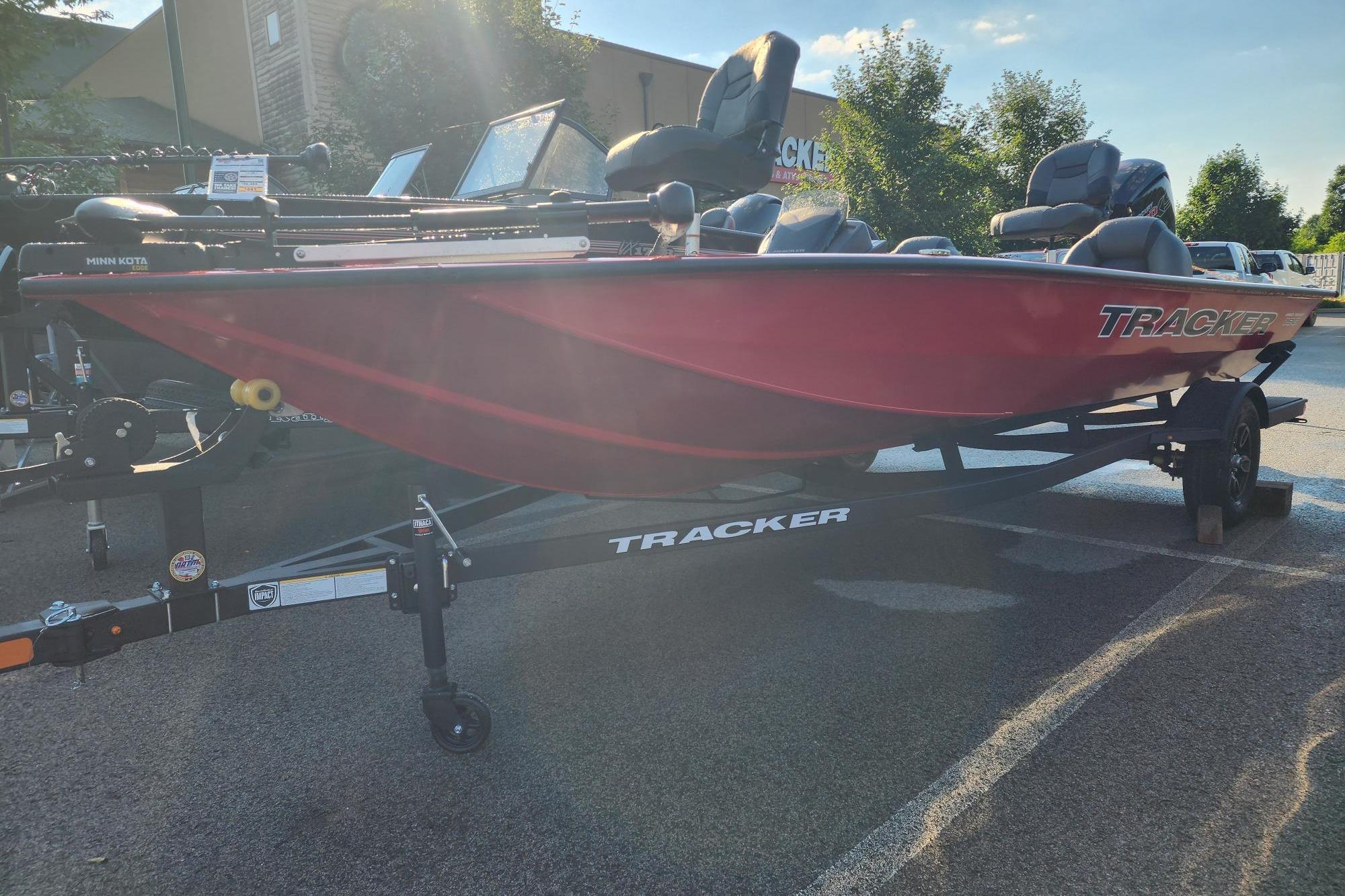 2026 Tracker Pro Team 190 boat in red on a trailer, parked outdoors.
