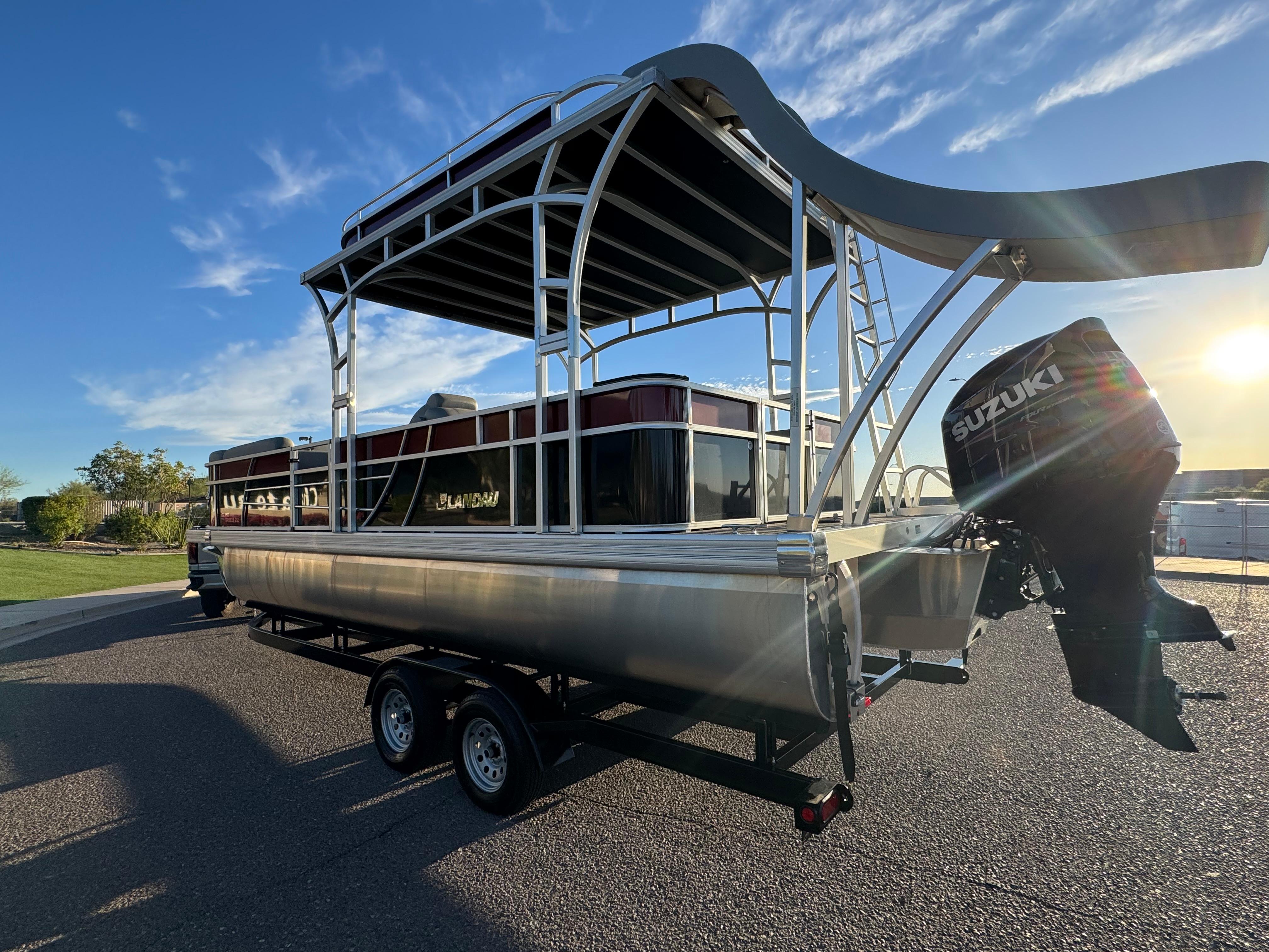 2024 Landau Island Breeze 252 pontoon boat with Suzuki engine, parked on a trailer.