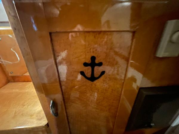 1951 Chris-Craft Catalina wooden interior with anchor design on cabinet door.