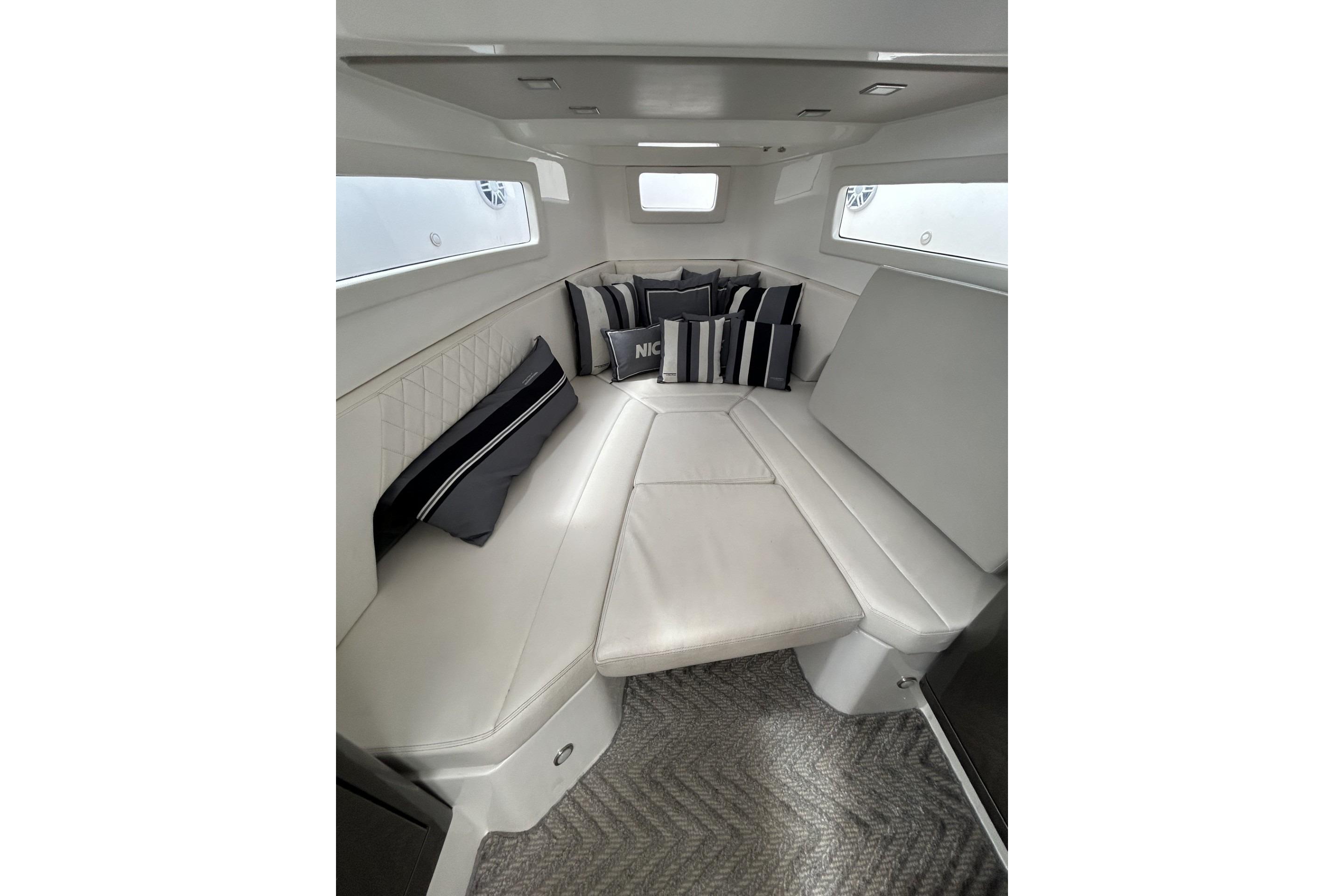 Luxurious interior of 2023 Schaefer V33 yacht with elegant seating and decorative pillows.