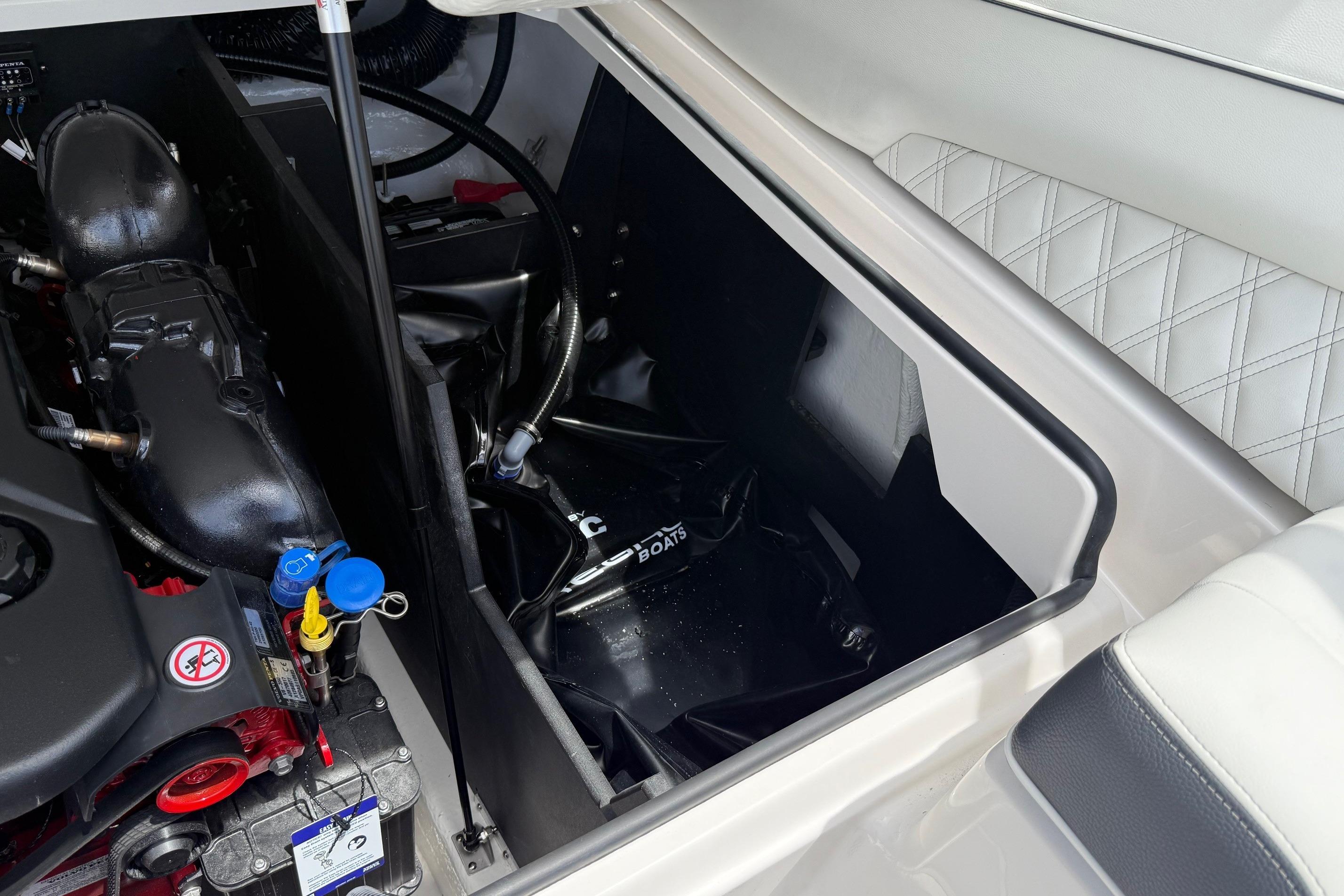 Engine compartment of 2026 Regal LS4 Surf boat, showcasing mechanical components and storage area.