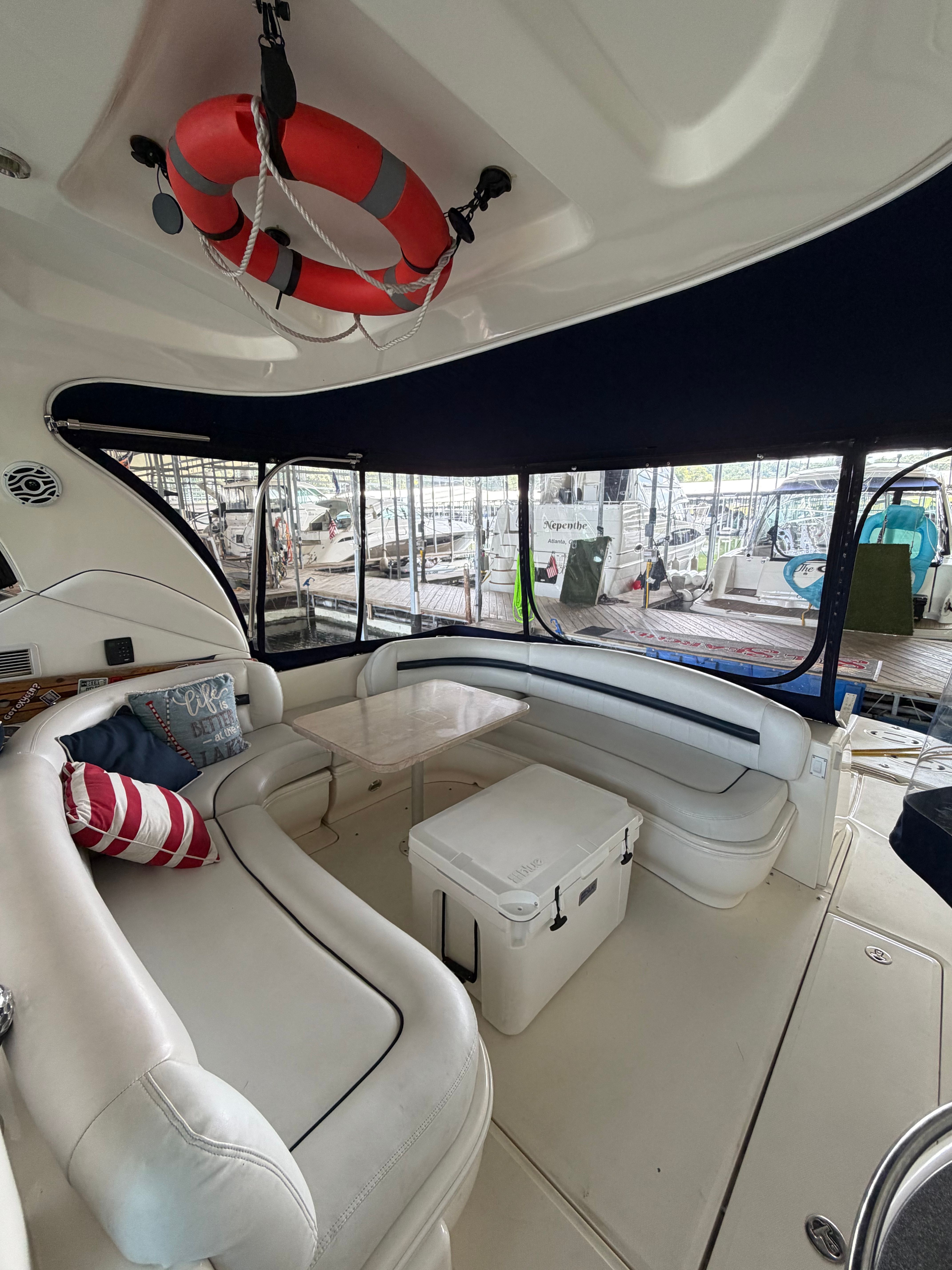 Interior of a 2005 Sea Ray 420DA with curved white seating and a table.