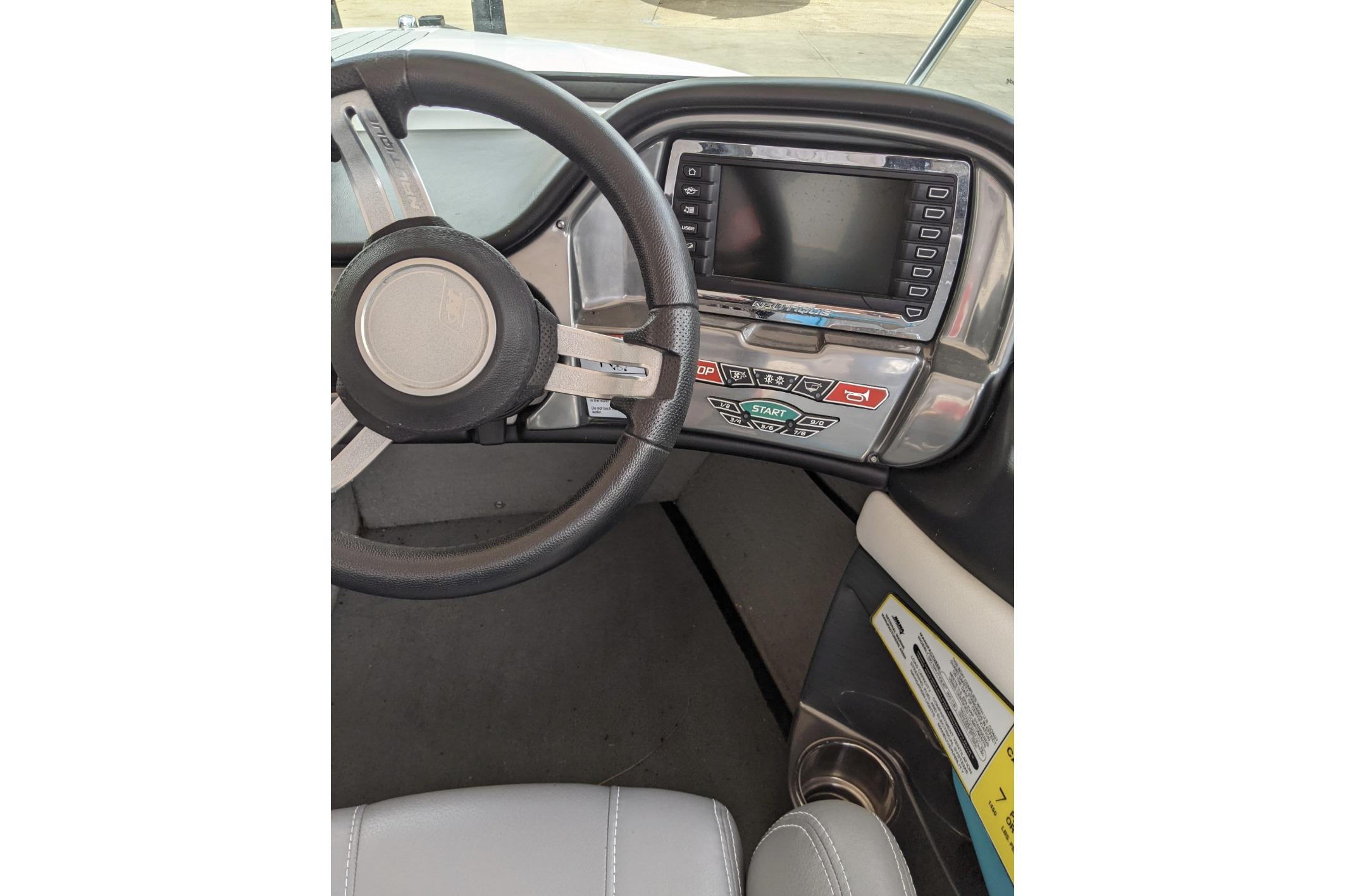 2016 Nautique Ski Nautique 200 Closed Bow dashboard with steering wheel and control panel.