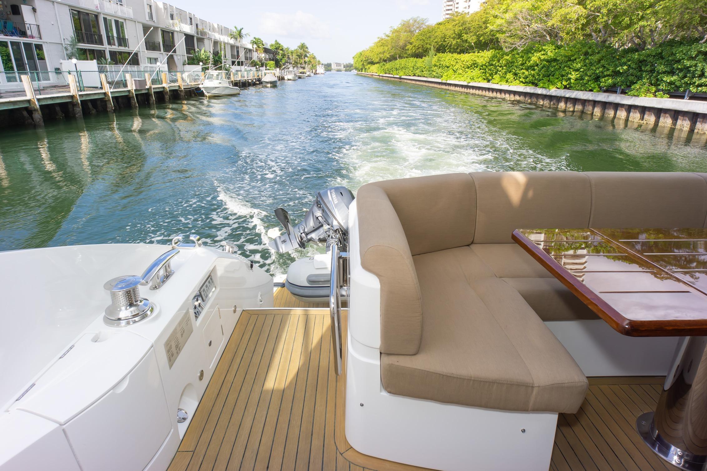 Luxurious 2018 Sunseeker Manhattan 52 yacht cruising along a scenic canal.