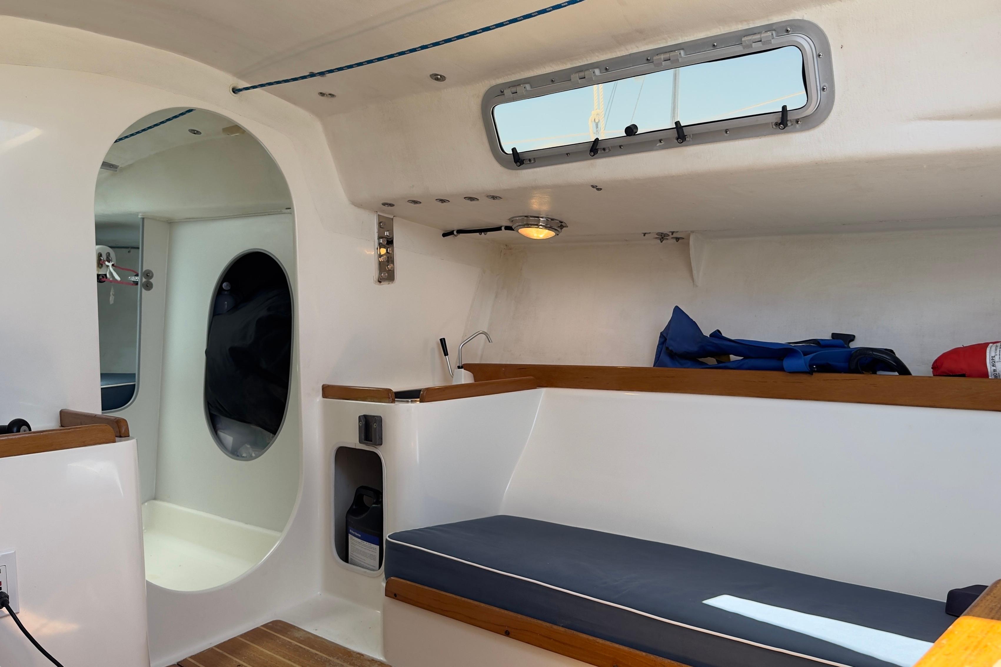 Interior of a 1994 J Boats J/92 sailboat, featuring seating and storage areas.