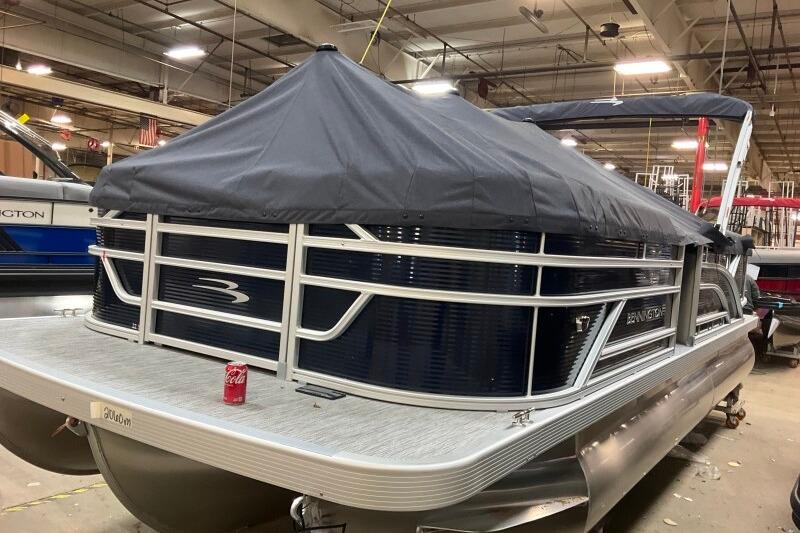 2026 Bennington 22 SSRSF pontoon boat with cover in a showroom.
