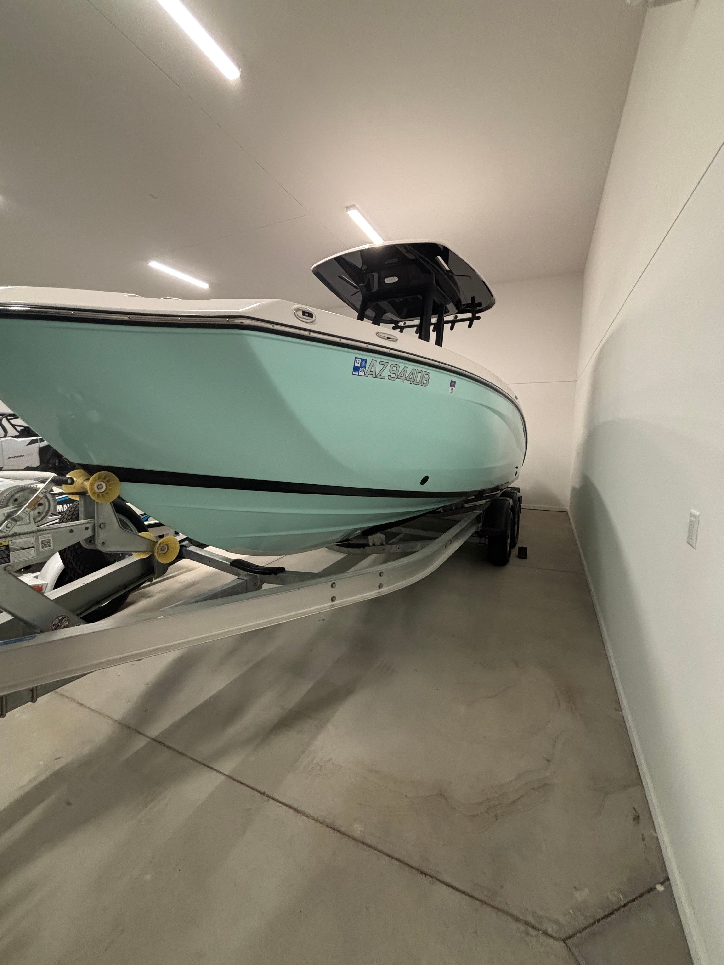 A 2025 Yamaha 222 FSH Sport E boat on a trailer inside a building.