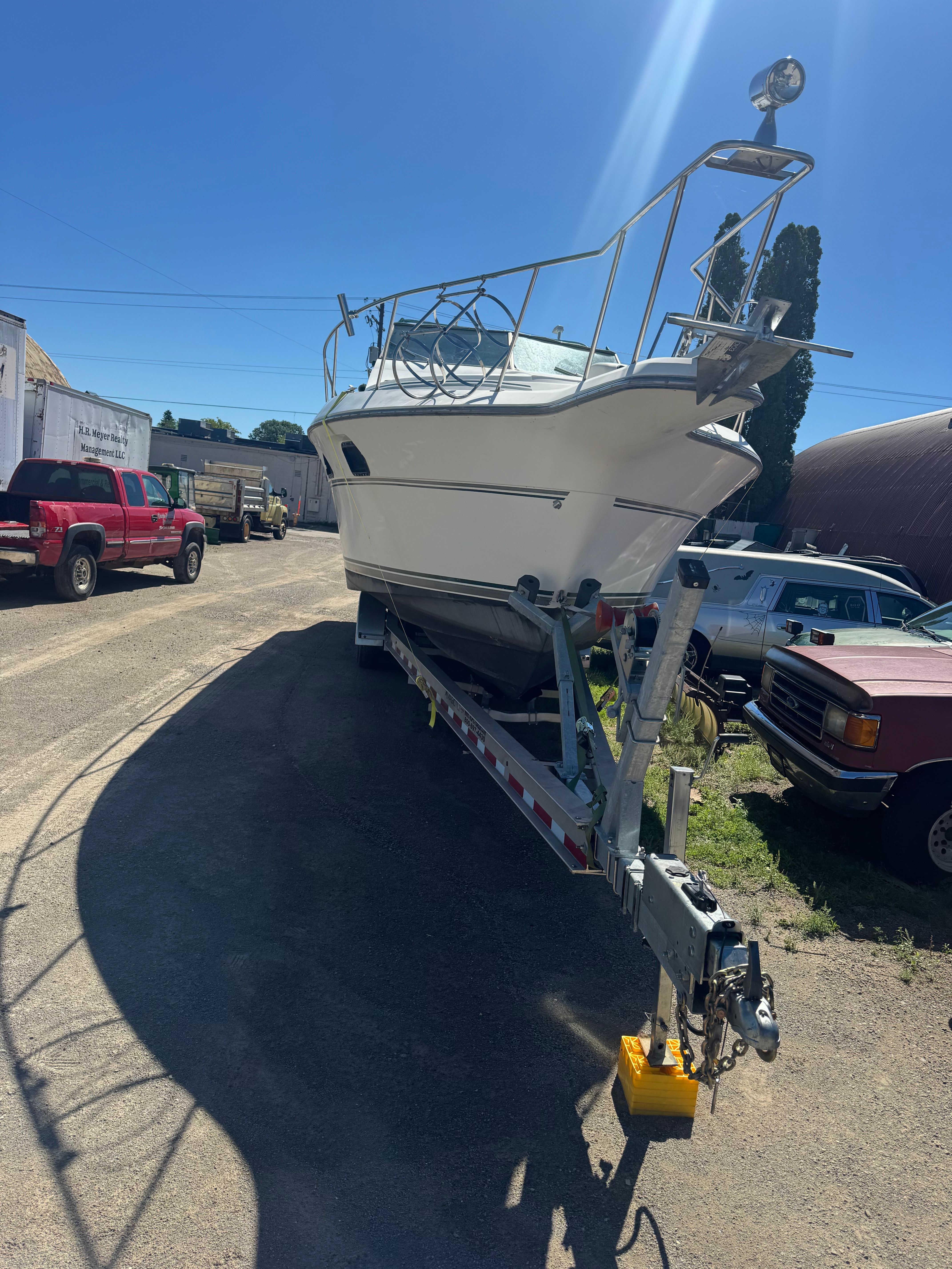 A 1992 Cruisers Yachts Esprit 3370 on a trailer, parked in a sunny area.