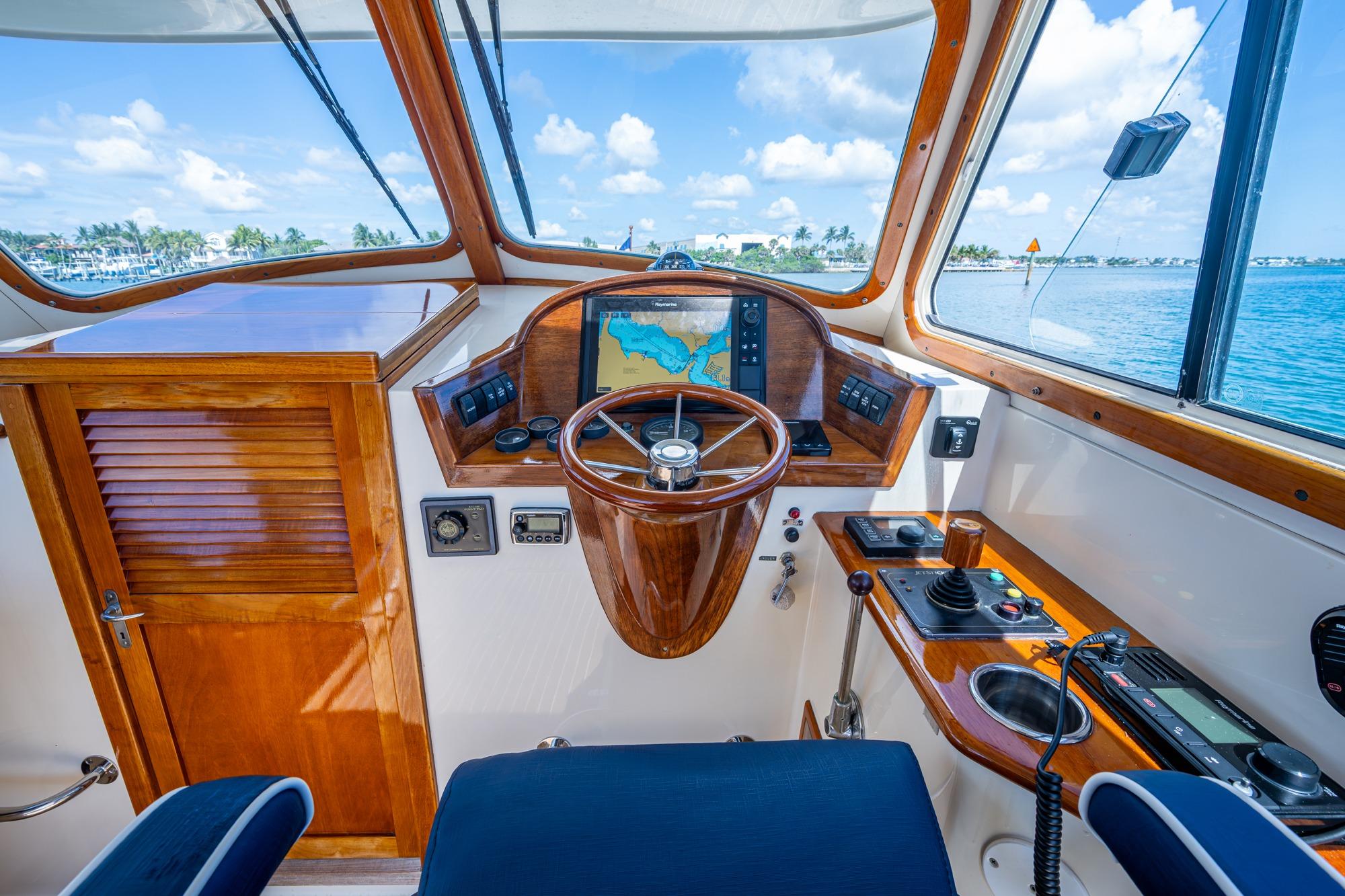2001 Hinckley Picnic Boat Classic helm with wooden steering wheel and navigation system.