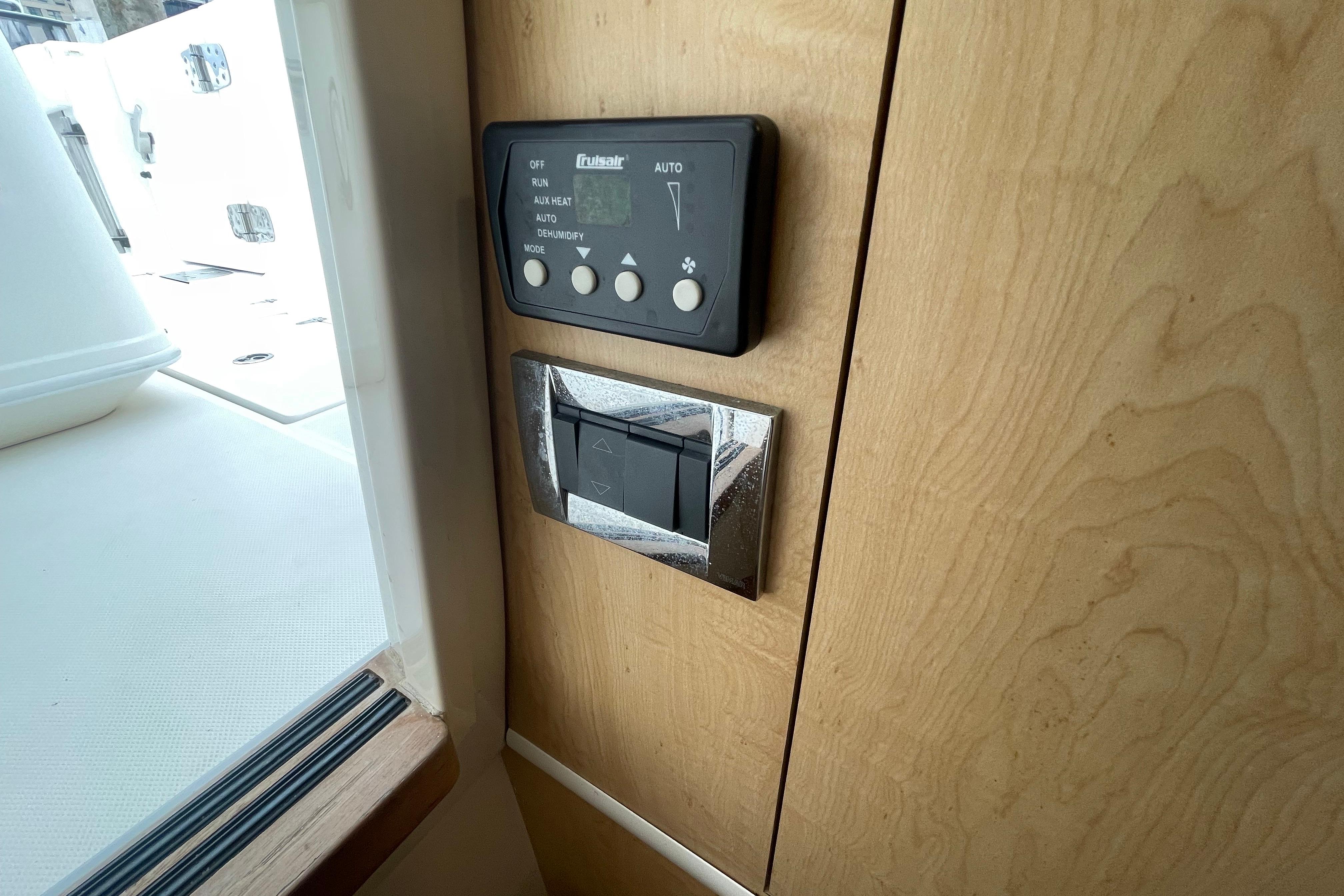 Control panel on 2015 Boston Whaler 370 Outrage boat interior, featuring wood finish.