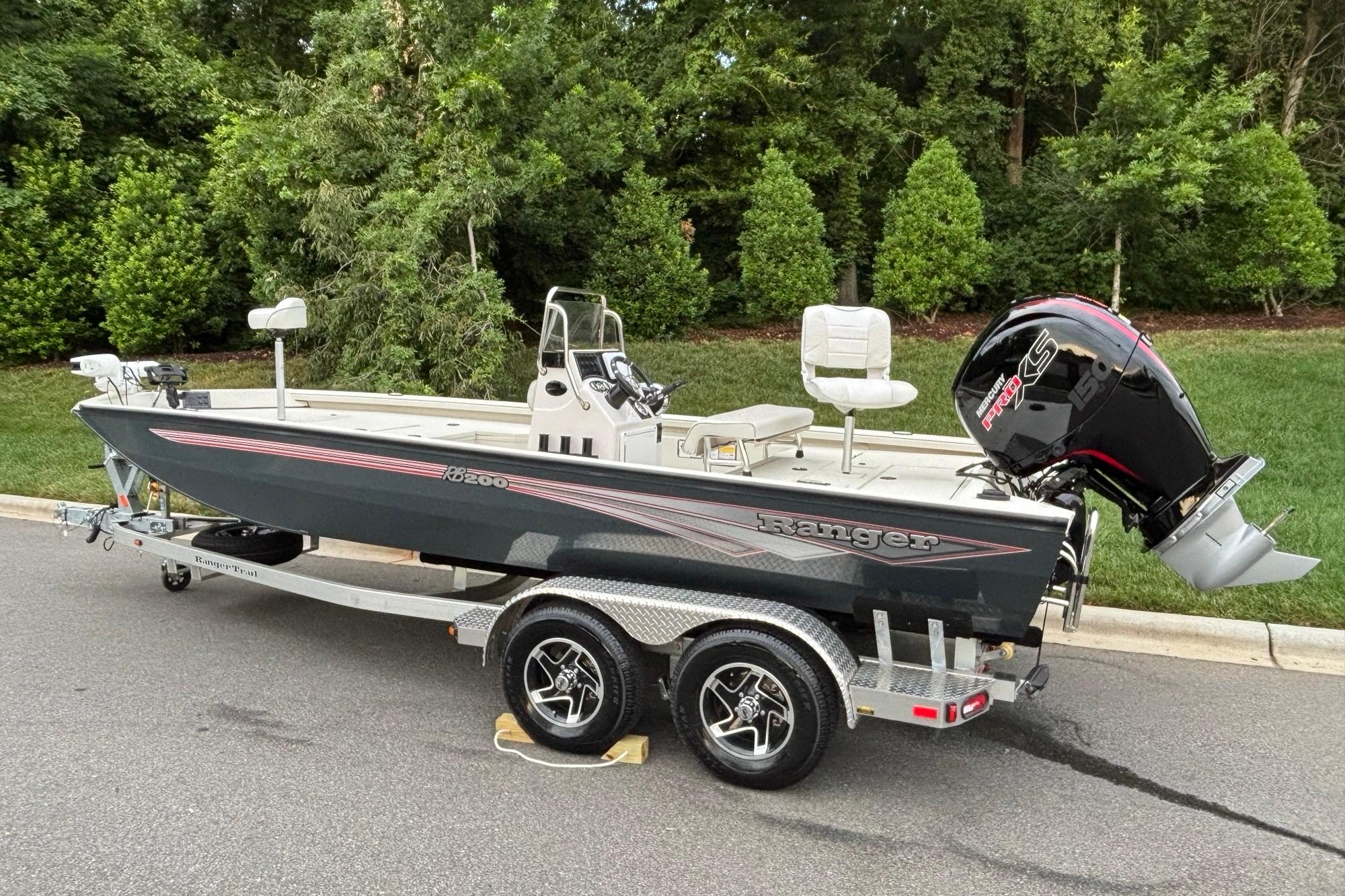 2024 Ranger RB200 boat on trailer, parked on road with lush greenery background.