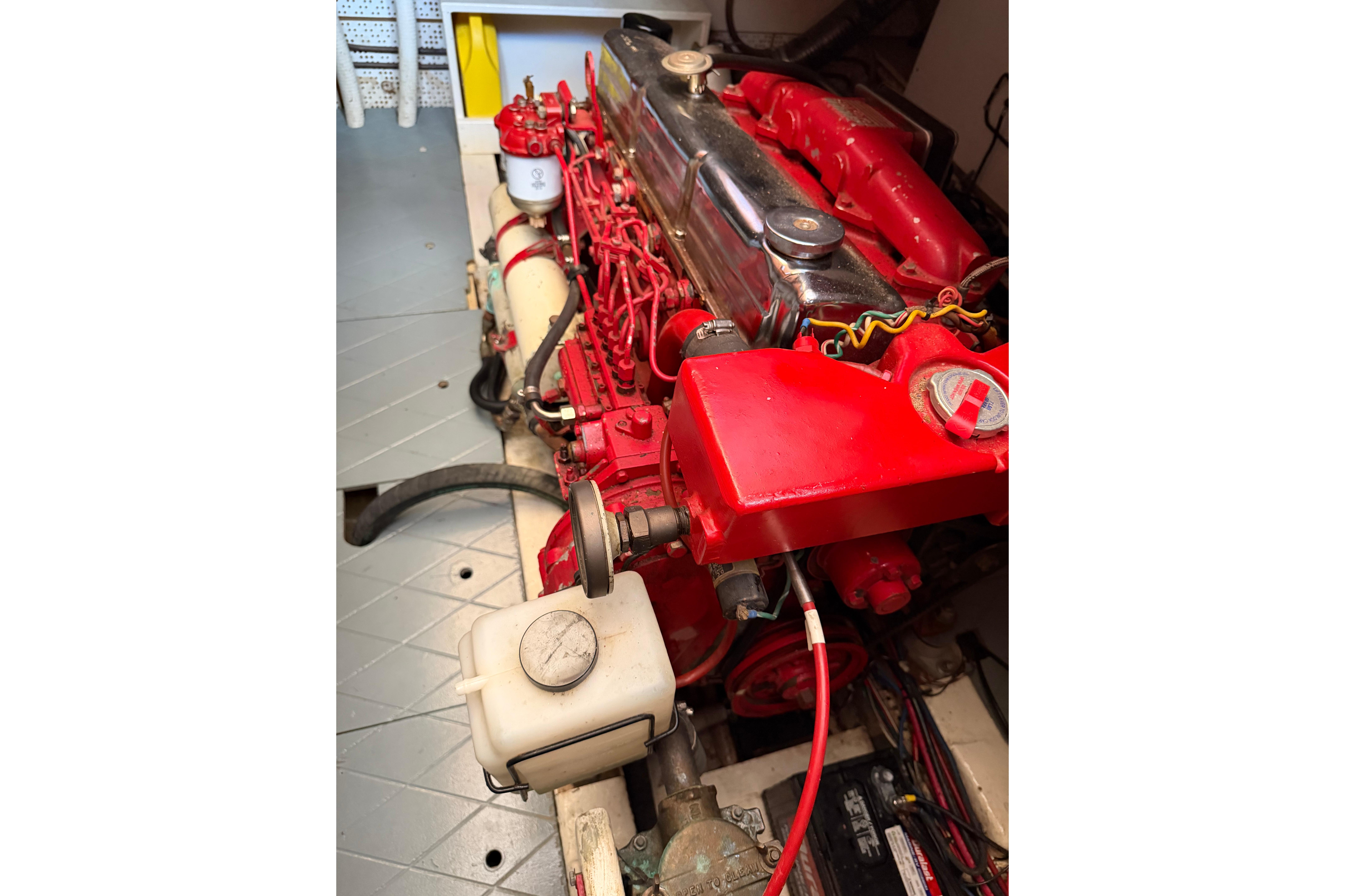 Engine of a 1987 Marine Trader 36, featuring red components and detailed wiring.