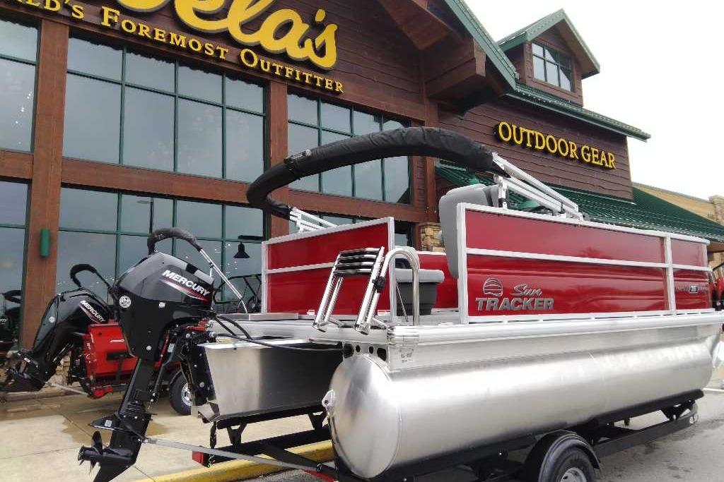 2026 Sun Tracker Party Barge 16 DLX pontoon boat displayed outside outdoor gear store.