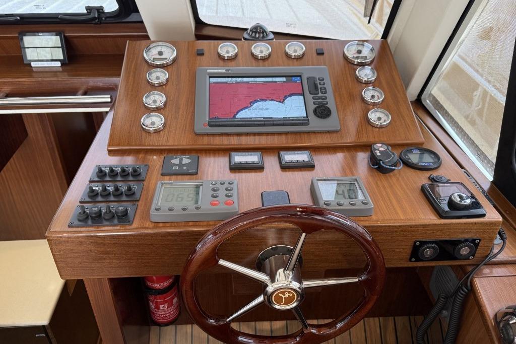 Control panel of a 2012 Sasga Yachts Menorquin 42 with navigation instruments and steering wheel.