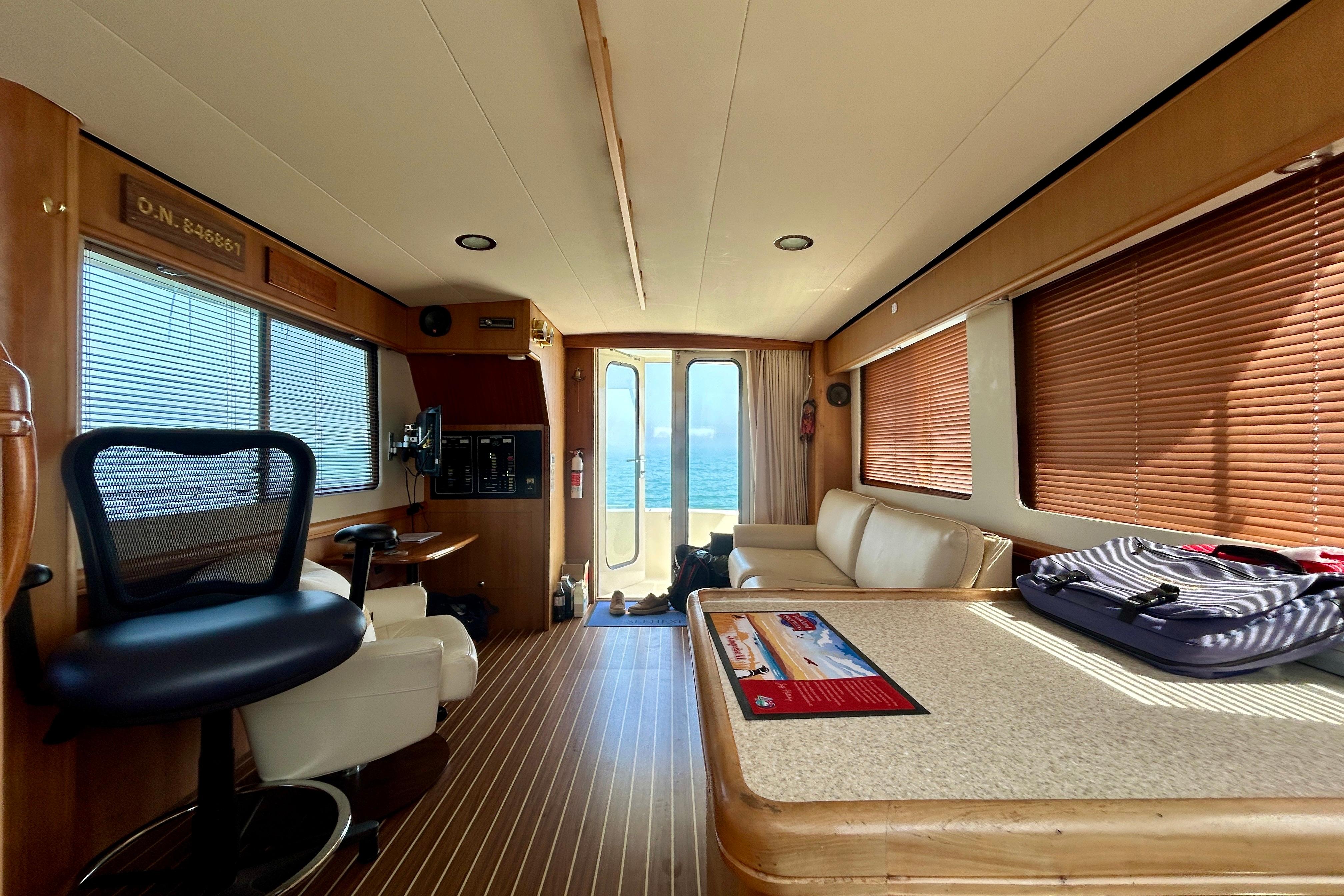 Interior of 2006 Mainship 34 Trawler with modern furnishings and ocean view.