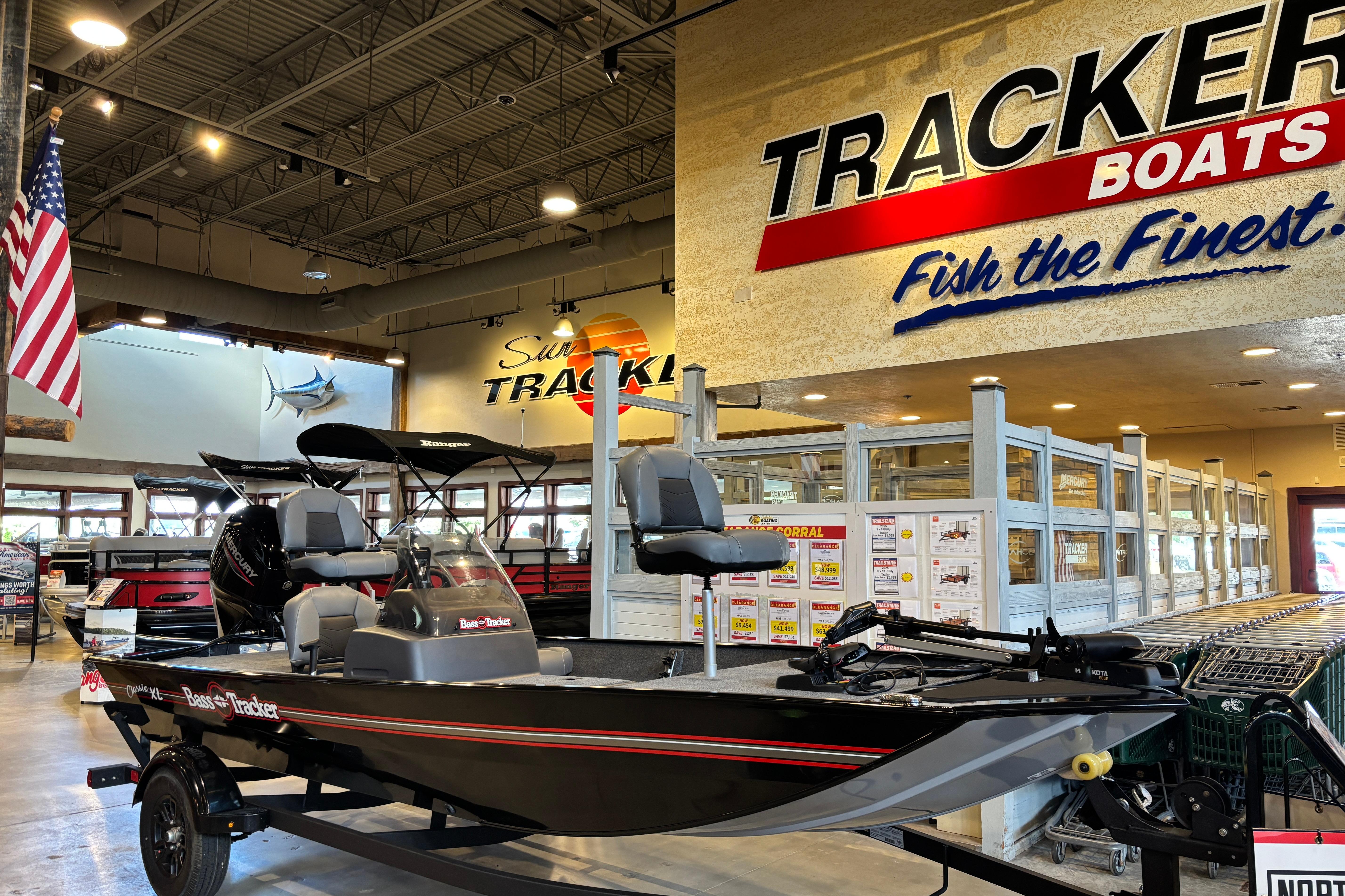 2026 Tracker Bass Tracker Classic XL boat displayed in showroom with promotional signage.