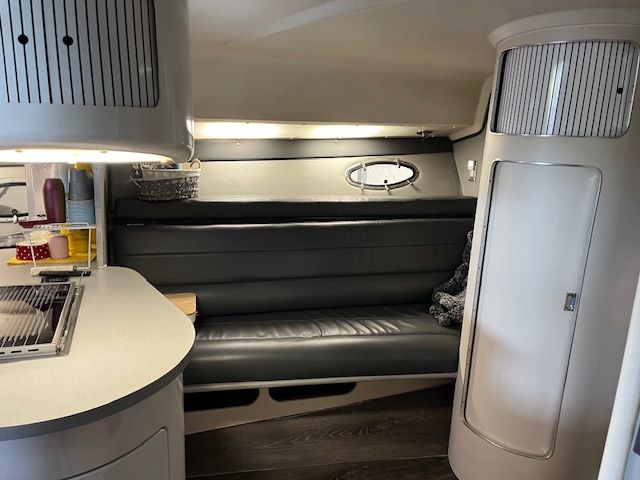 Interior of the 1989 Trojan 370 Express with gray sofa and rounded cabinets.